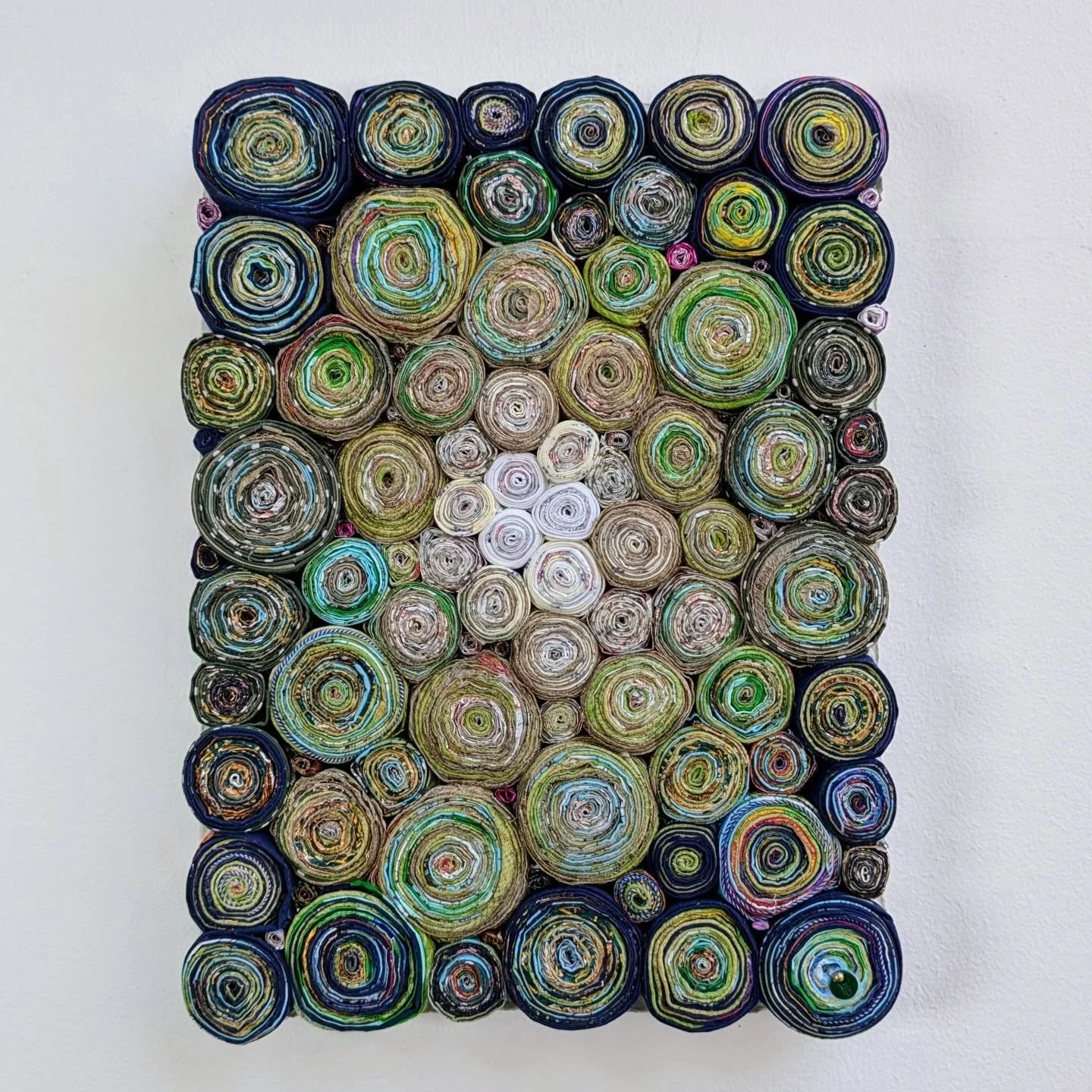 Kale, 2025. 100% waste: used hairdresser&rsquo;s foils, toilet paper wrap and leftover fabric (23x30cm).
Half hidden by the green bag of garden waste, in the front lawn of an Edwardian house in Ealing. Straw hat, polka dot gloves. Crouched among som