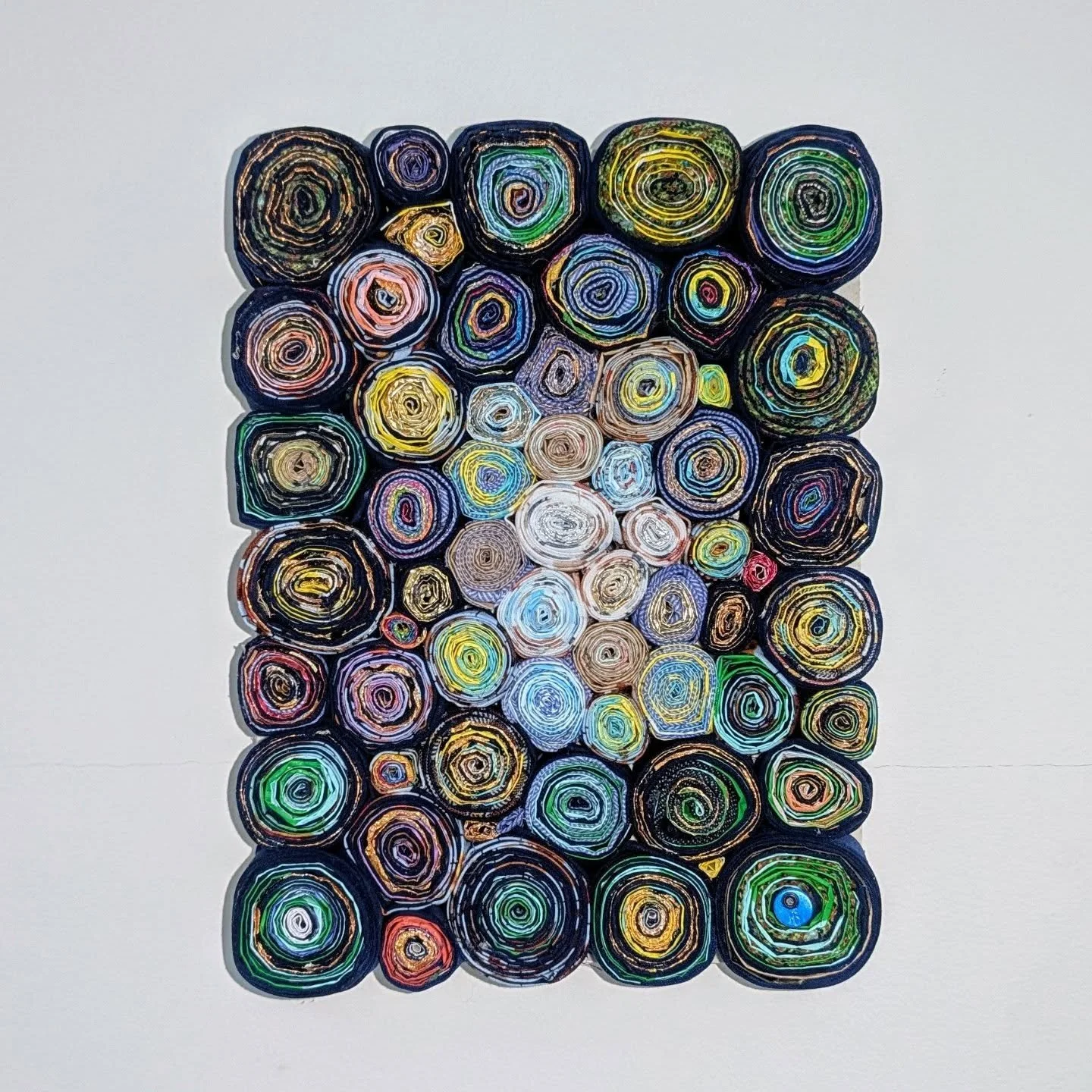 Lesley, 2025. 100% waste: used hairdresser&rsquo;s foils, toilet paper wrap and leftover fabric (15x20cm). SOLD
Dressed in an asymmetrical blue coat with golden patterns, a green scarf, and a scarlet cuff, strides confidently through Brixton market. 