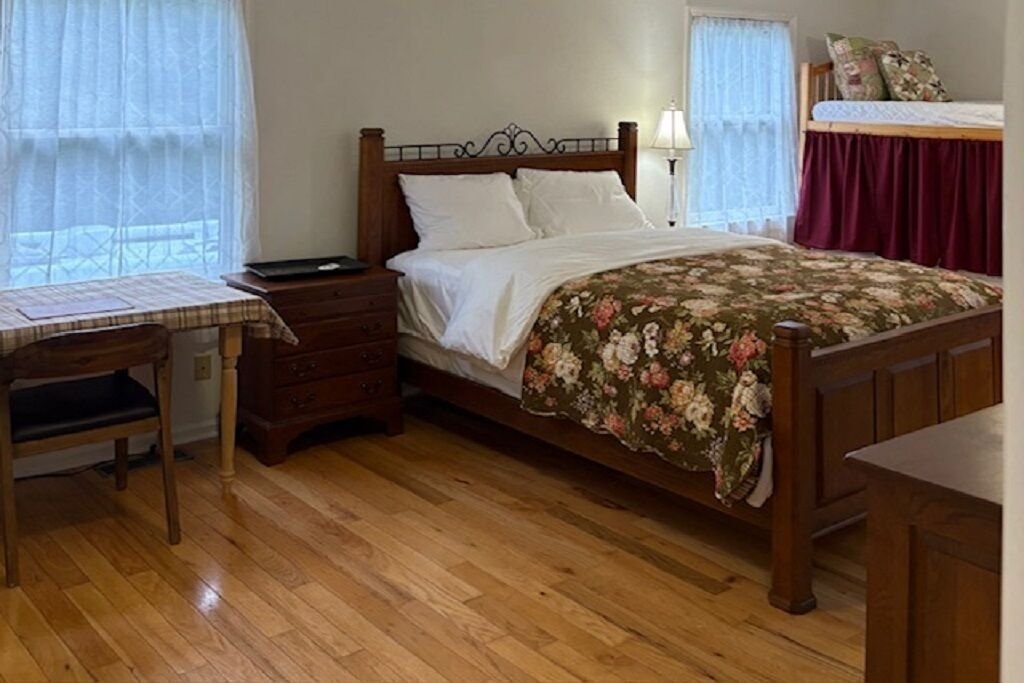 A bedroom in the farm house with a queen bed and a quilt