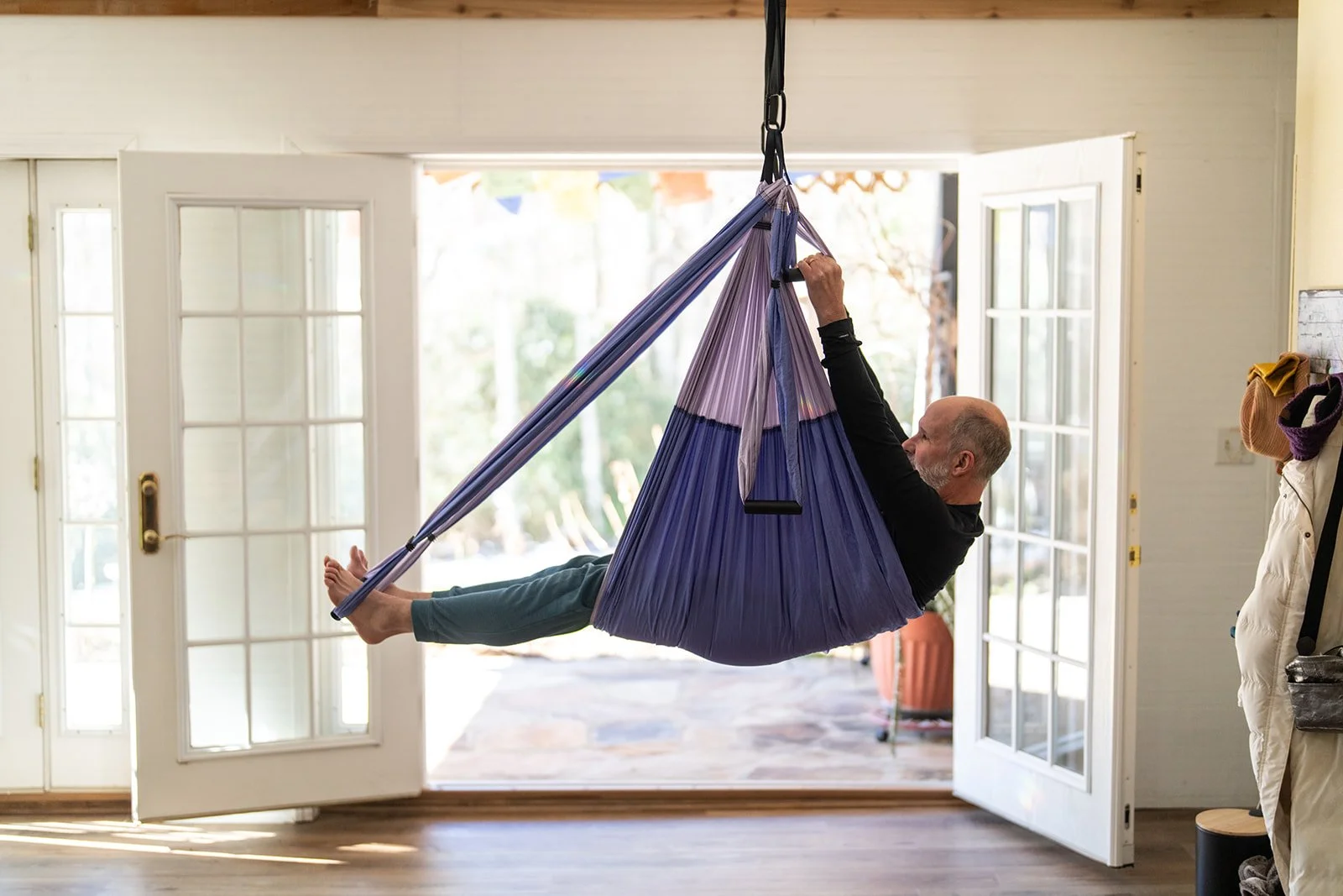 A client hanging upside down in an aerial yoga hammock in the studio