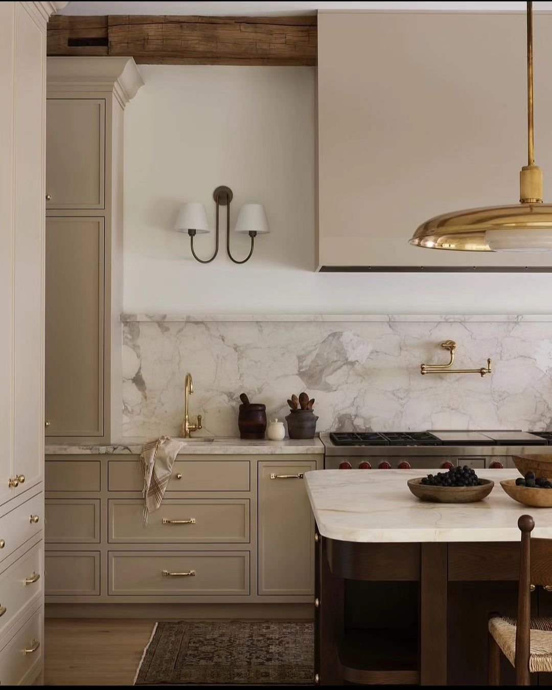 Cook in ultimate style and luxury! 🍽️✨ This kitchen boasts a stunning one-piece marble backsplash, an industrial gas stove with an extendable faucet, and a hidden vent hood seamlessly integrated with floor-to-ceiling custom cabinetry. Ready to make 