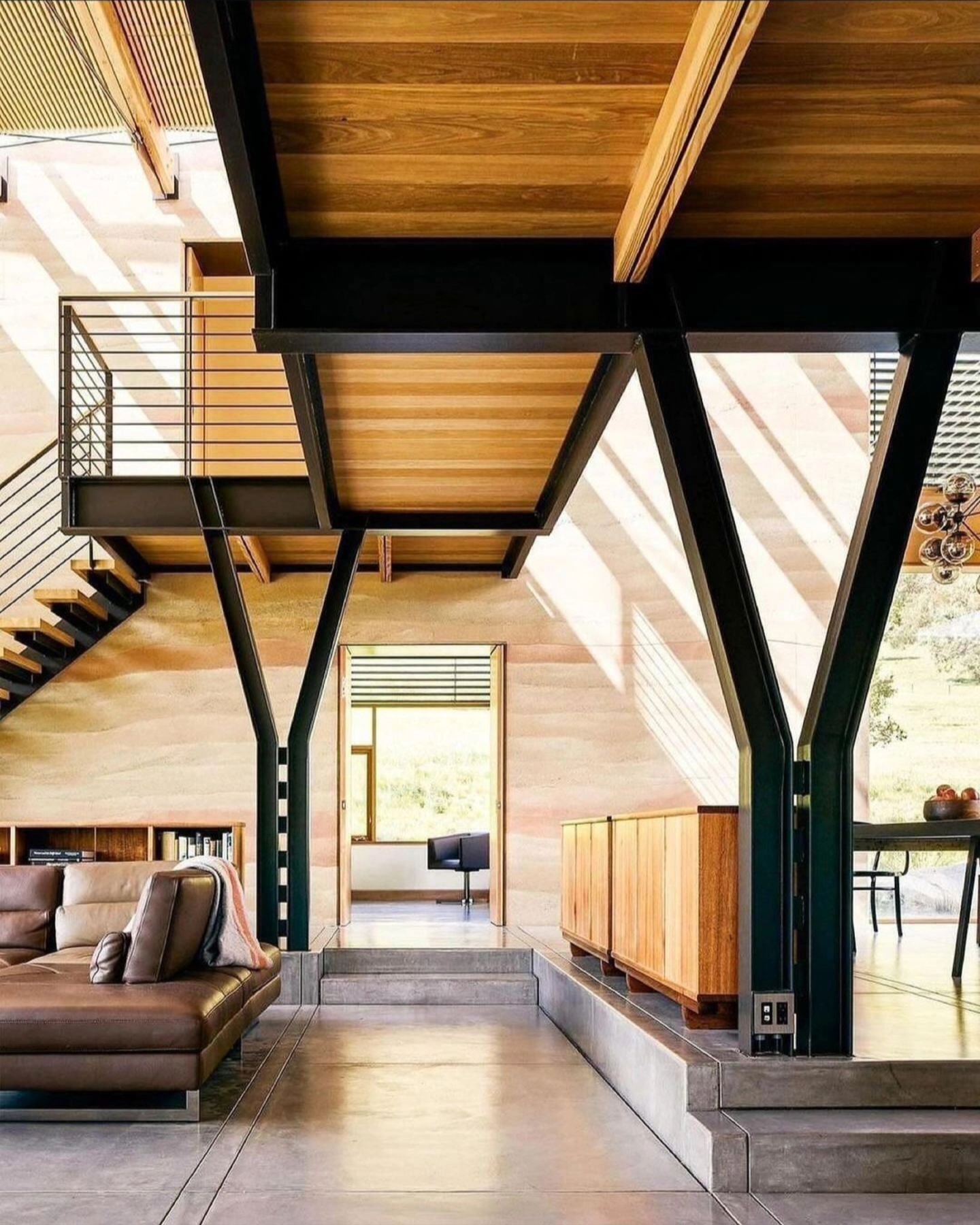 Modern living with a bold twist! 🌟 This stunning space features a lofted walkway supported by Y-shaped steel beams, floating stairs, and a bright open concept kitchen and living room flooded with natural light. ☀️&nbsp;Can you see yourself in this m