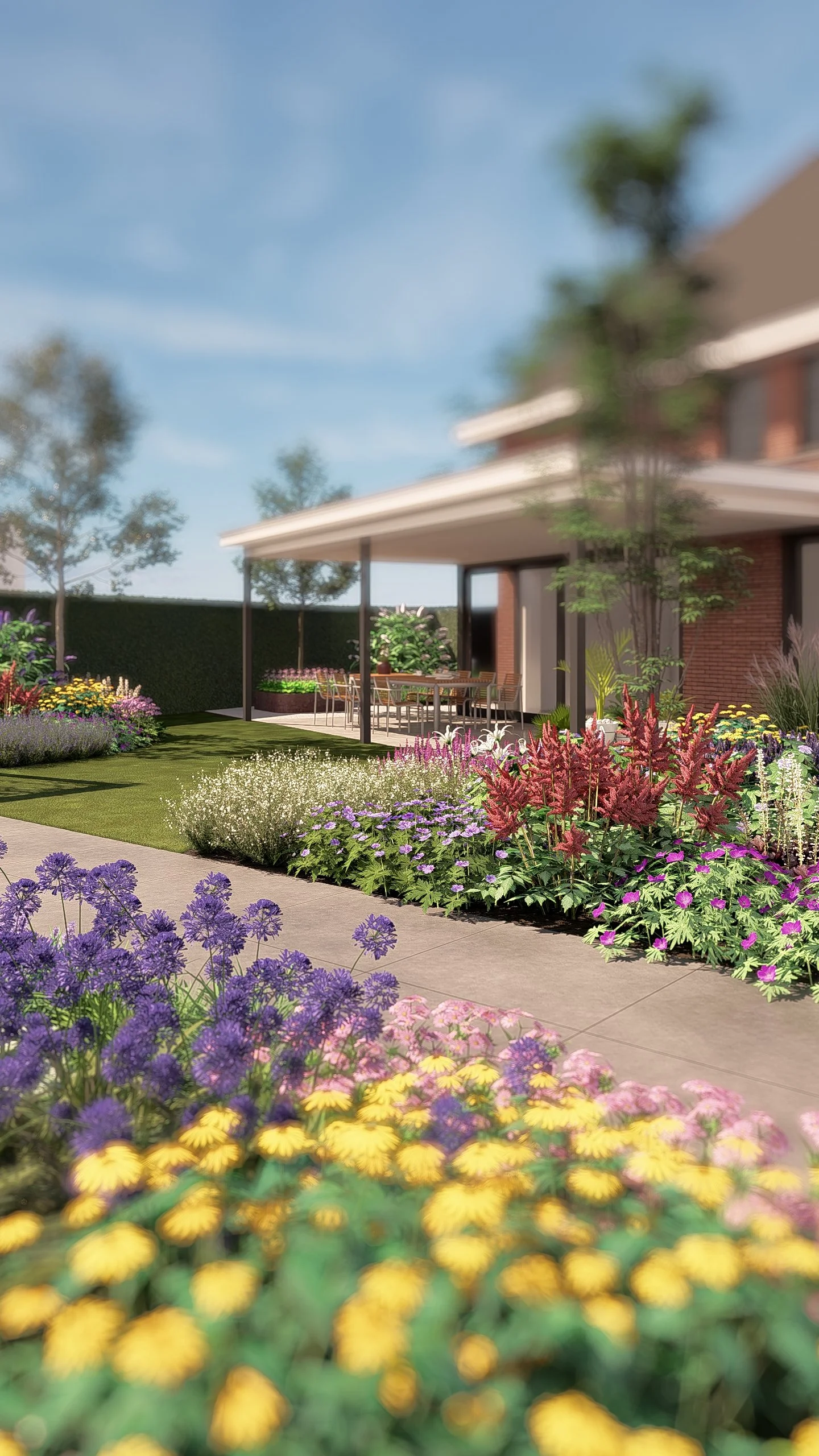 Een kleurrijke tuin met diverse bloemen, een terras met eet- en tuinstoelen onder een veranda, en een huis op de achtergrond.