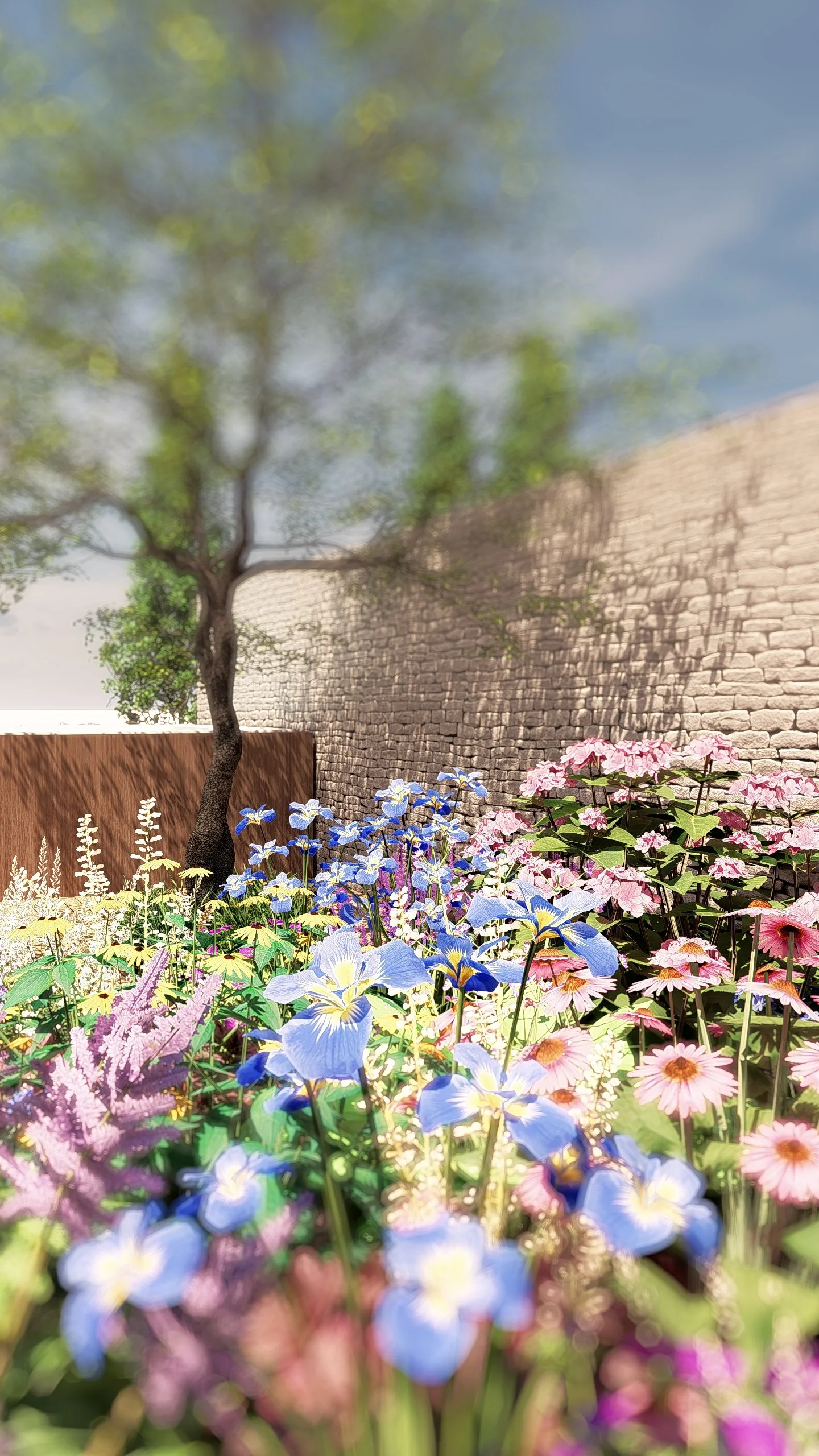 Tuin met een boom, betonnen muur en een bloemenbed met blauwe, roze en paarse bloemen in de voorgrond.