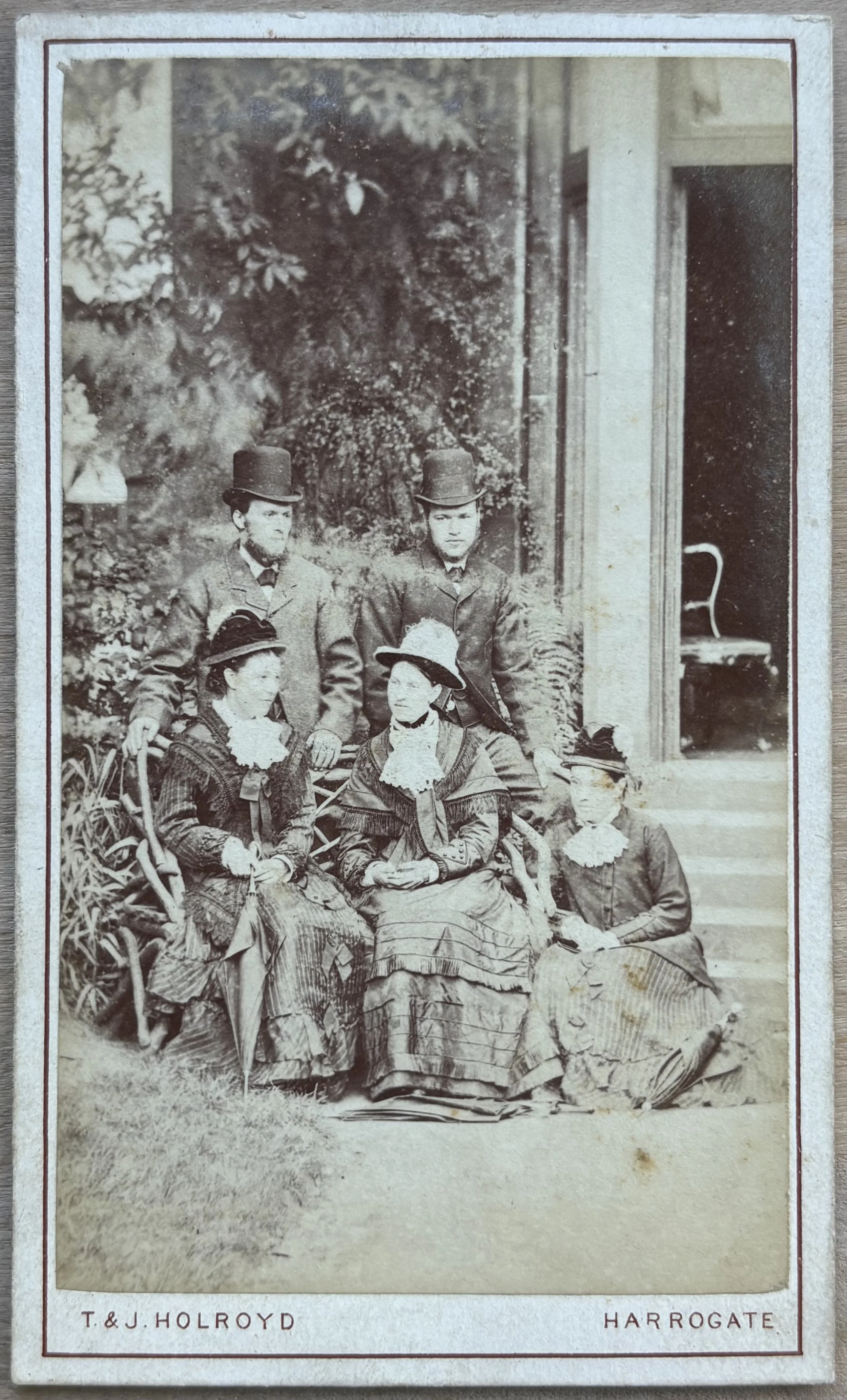 Portrait of a family group of five adults two men in hats and three women by Thomas and James Holroyd photographers of Harrogate
