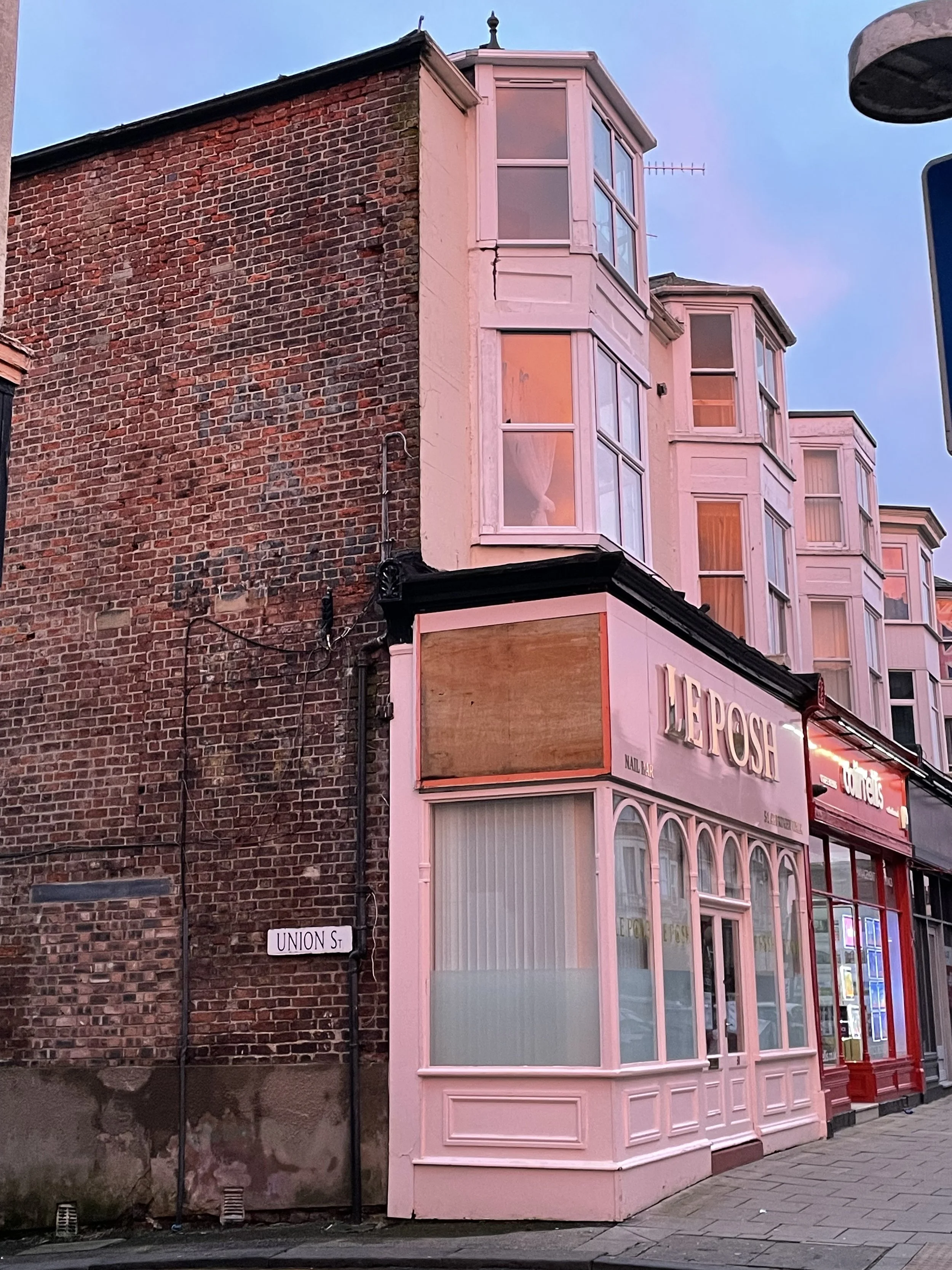 Side of shop in Aberdeen Walk, Scarborough with Ghost Sign