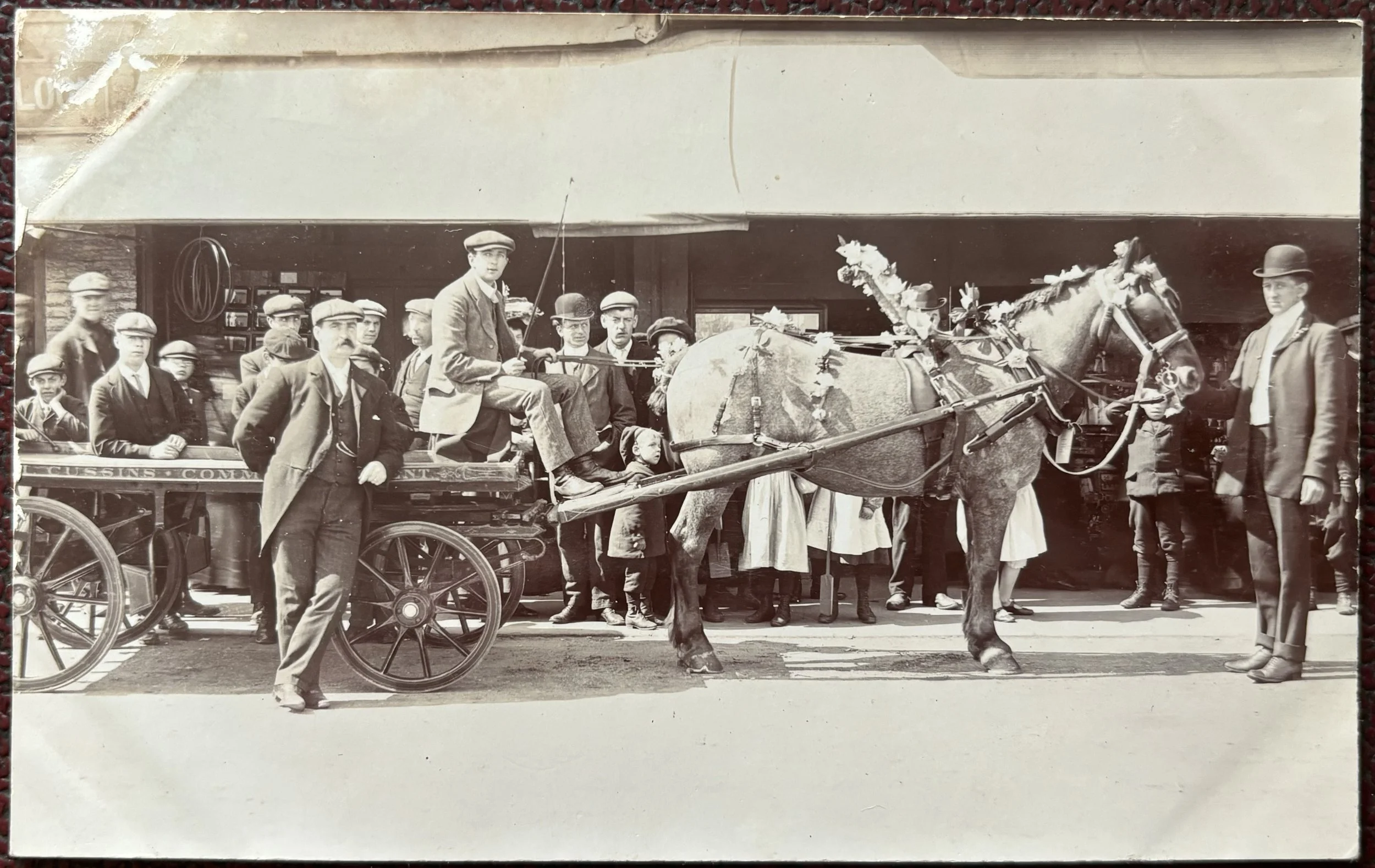 photographic postcard of a horse and cart in the street in Scarborough, Cussins.