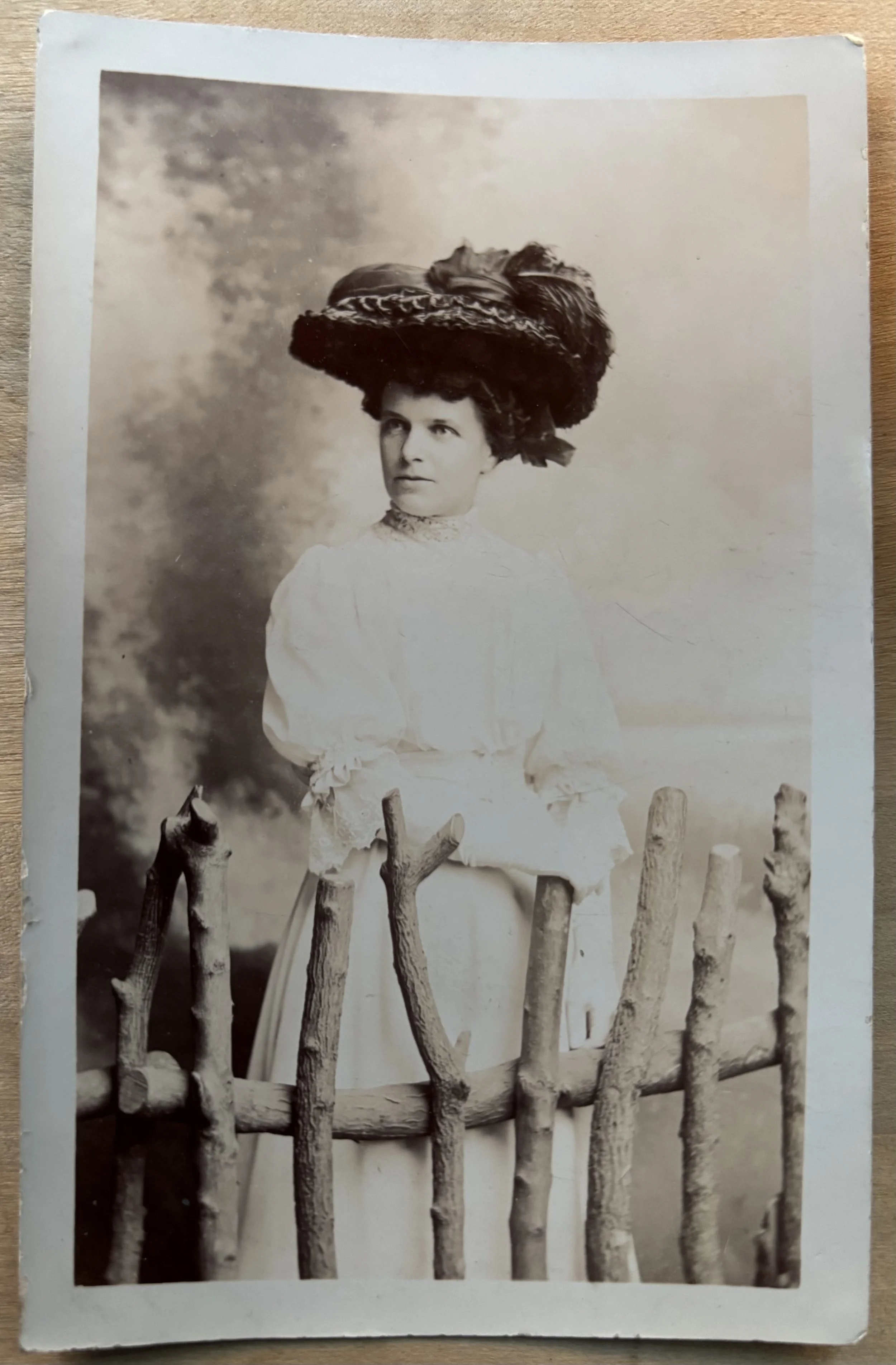 portrait of woman in a hat behind a fence in the photographic studio of Boxell and co, Scarborough
