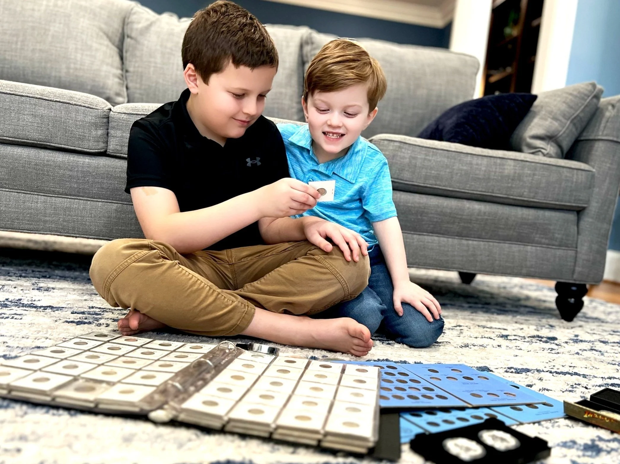 Two young numismatists examining coins in cardboard holders