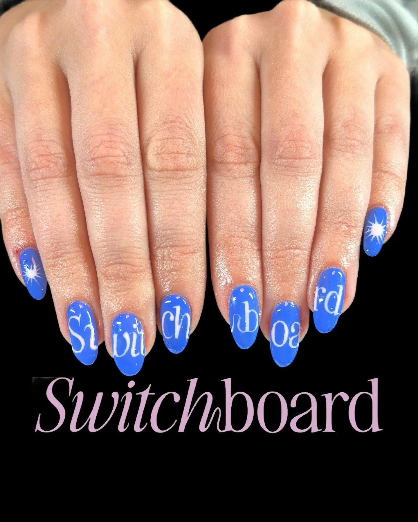 Blue nail polish with white alphabet letters and star designs on fingernails, spelling 'switchboard', with the word 'Switchboard' written below.