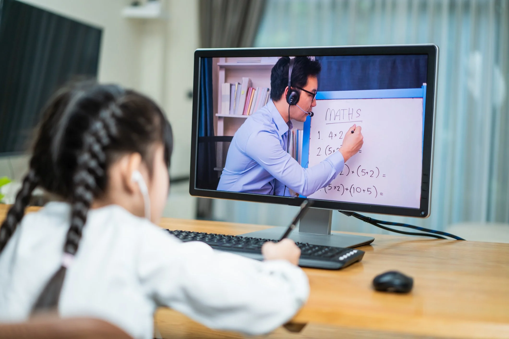Young student receiving virtual math tutoring from a Housecalls tutor on Zoom
