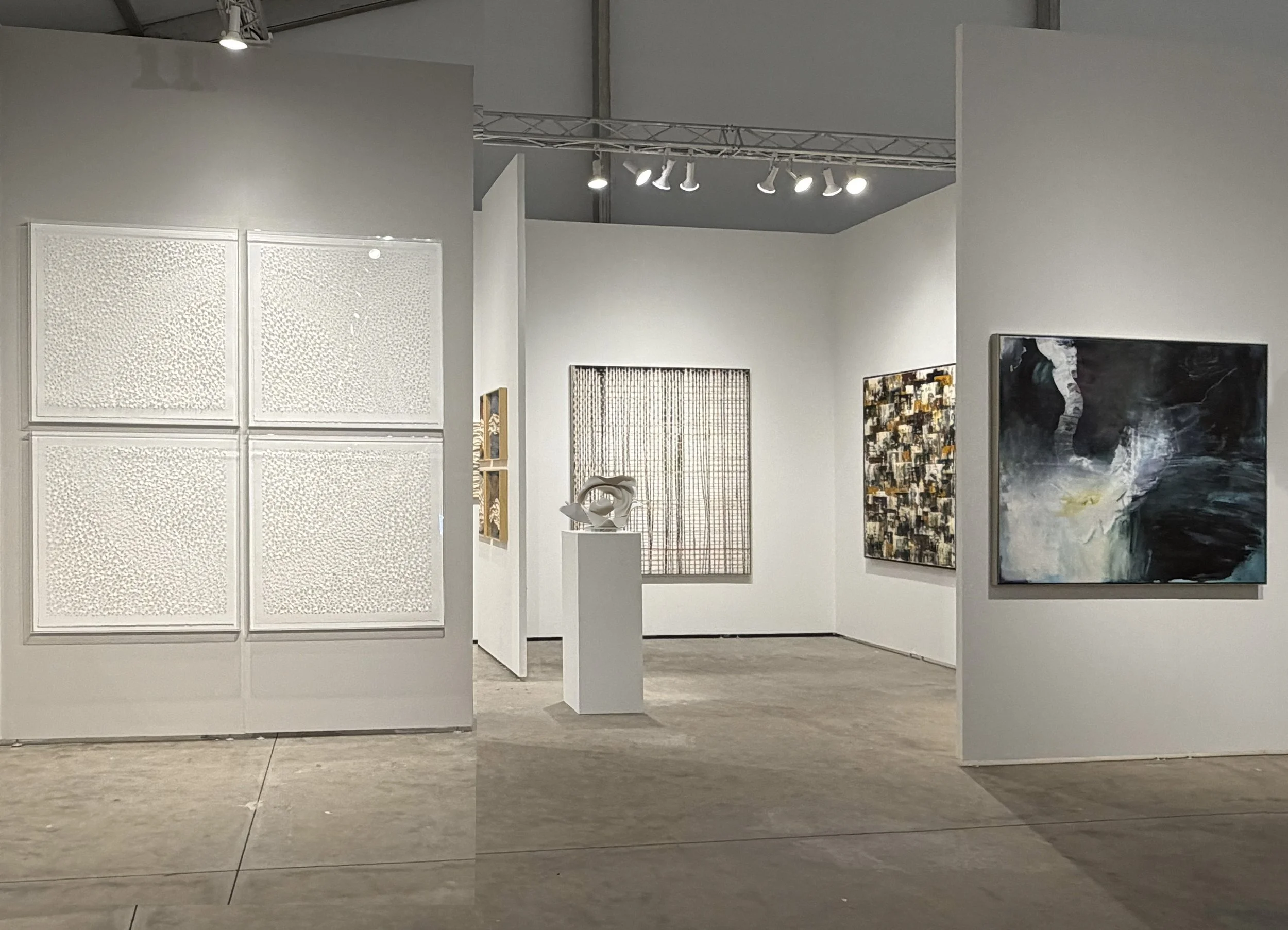 People walking and viewing artwork in an art gallery or exhibition space.