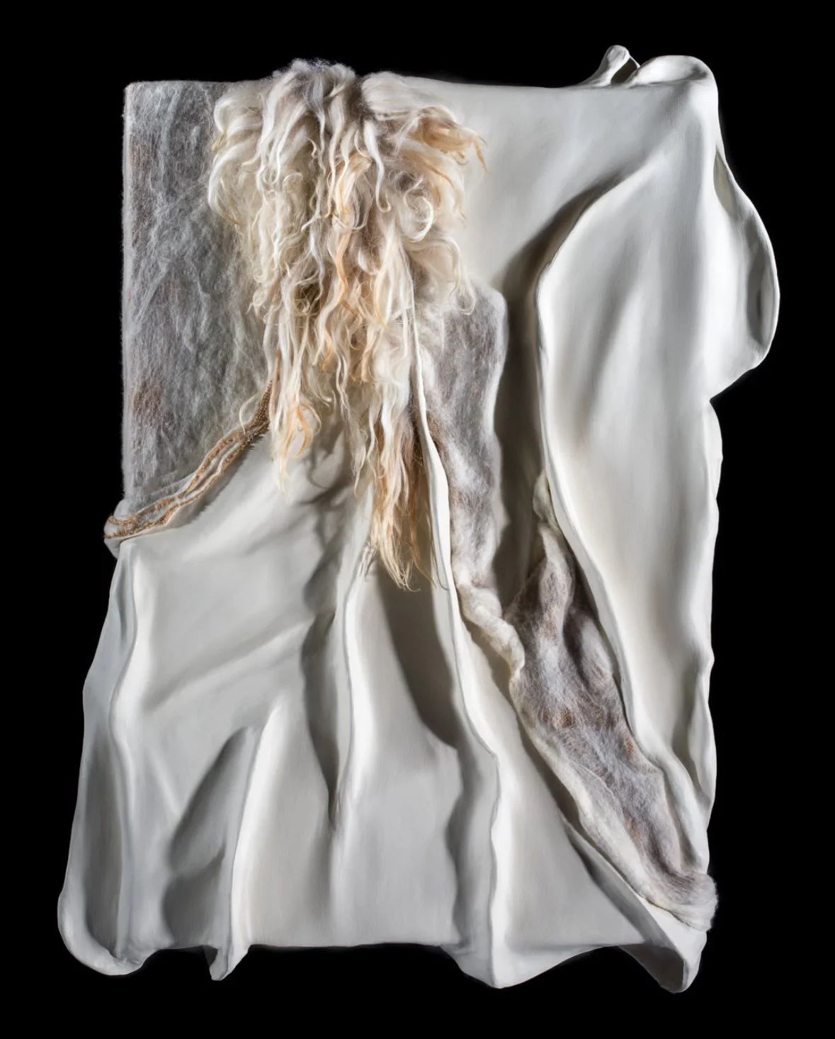 Abstract sculpture resembling a draped fabric with a textured, wavy edge and curly, blonde hair-like strands hanging from the top.