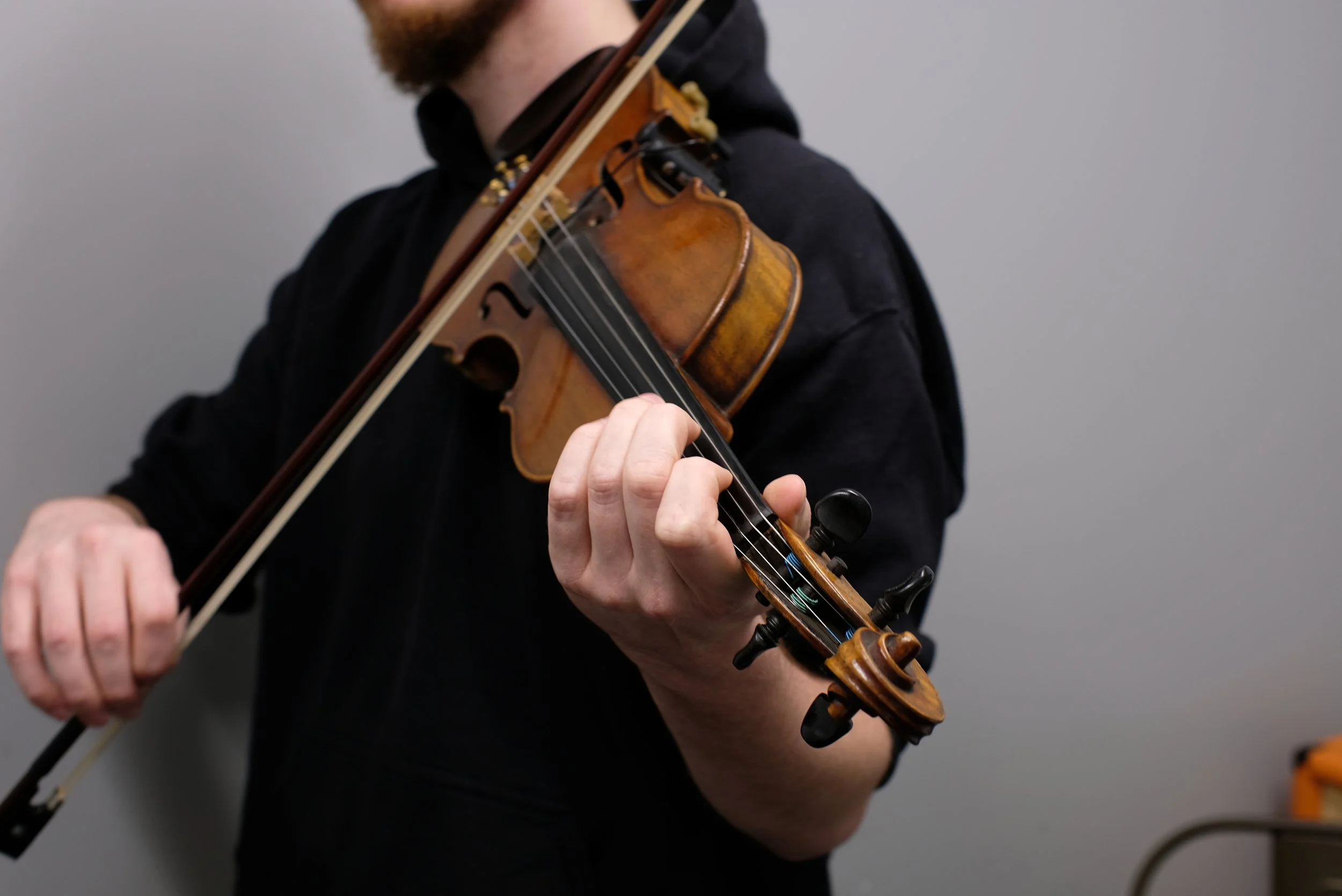 Adult student playing violin during a private lesson in Davidson, NC