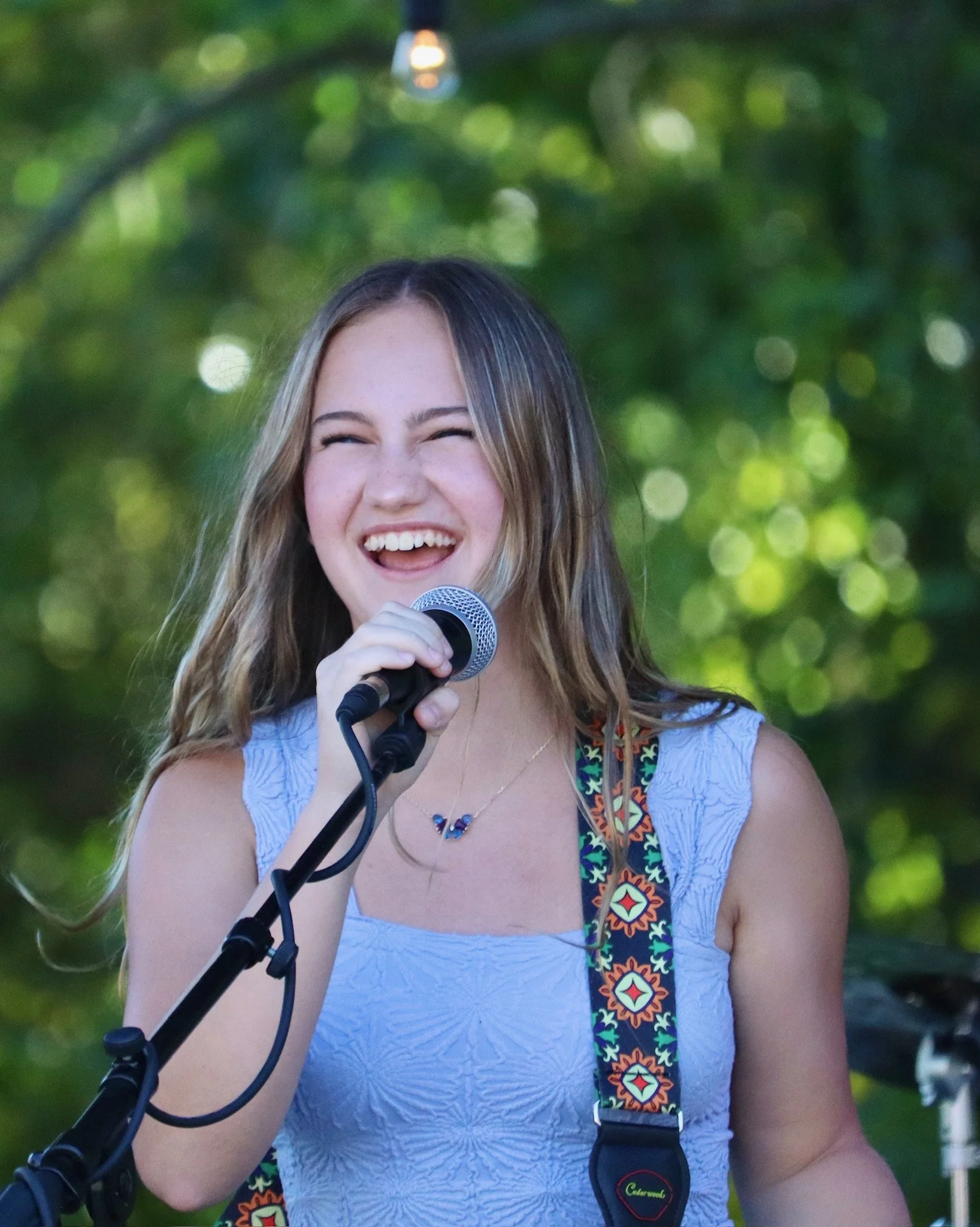 Teenage student smiling and singing in a Learn Music Legends rock band