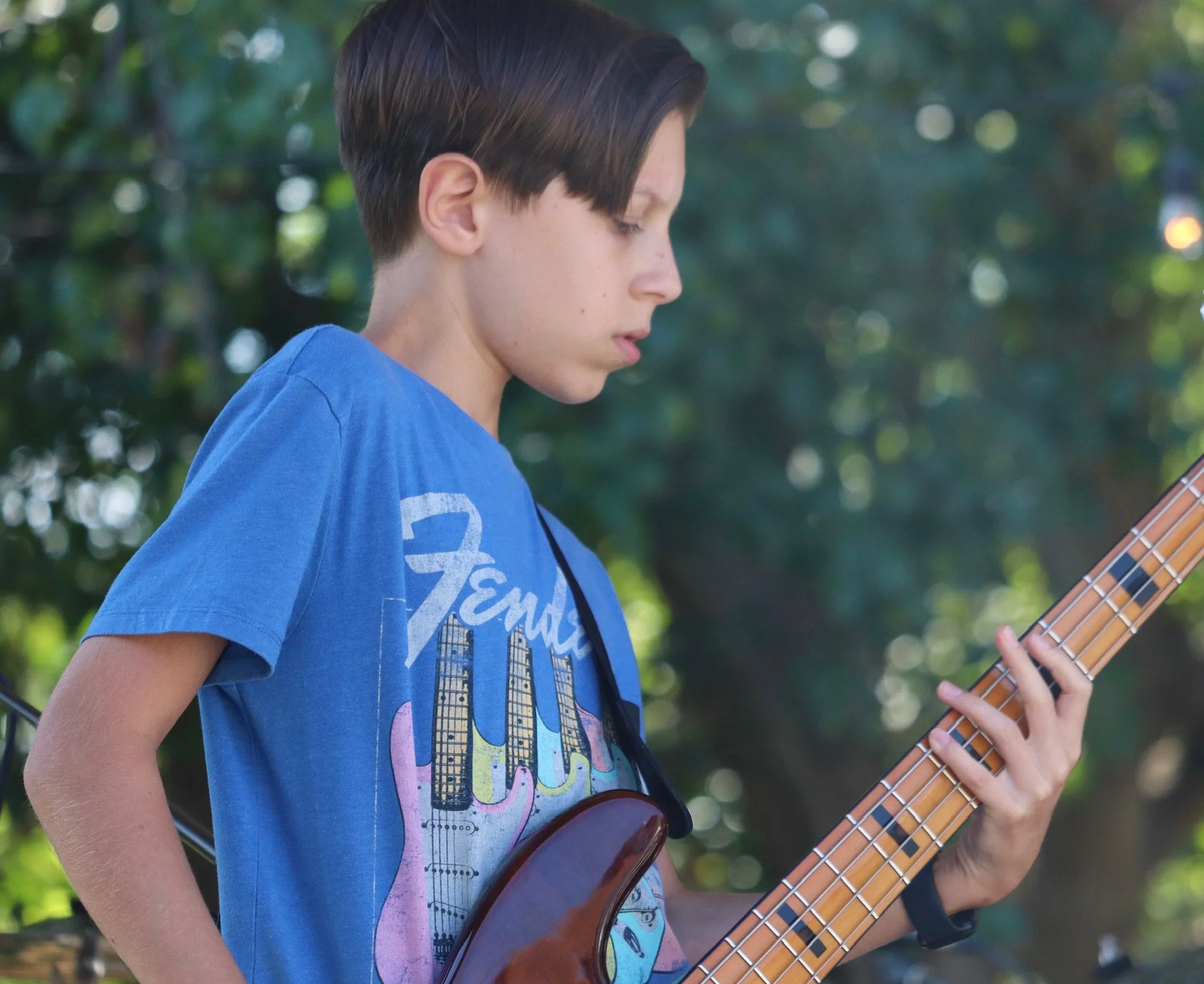 A middle school student playing bass in a student rock band near Cornelius, NC
