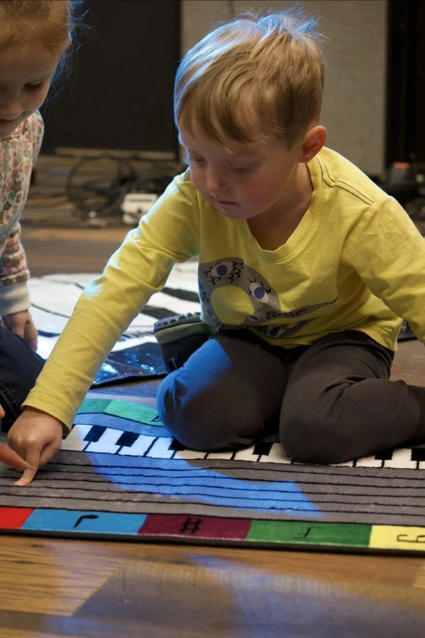 Preschooler exploring a new instrument during a Little Legends music class in Cornelius, NC