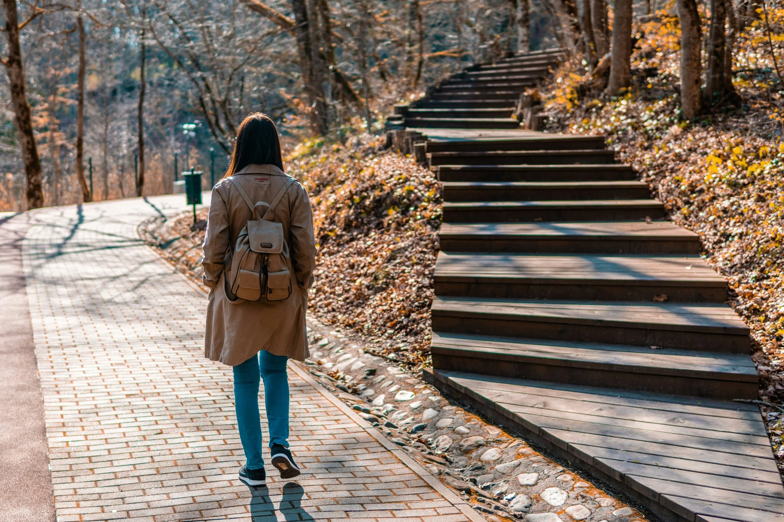 Woman taking a mental health walk outdoors during the day to reclaim personal time and reduce stress before the evening.