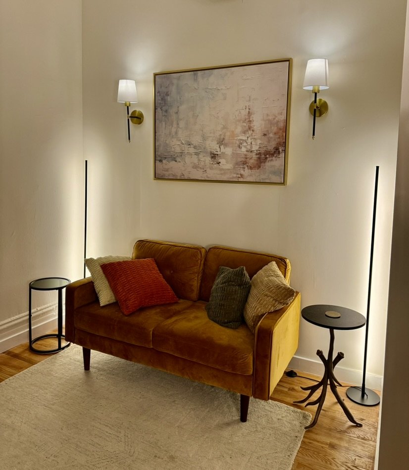 Therapy room at our Midtown Manhattan office, with a mustard velvet loveseat and soft lighting