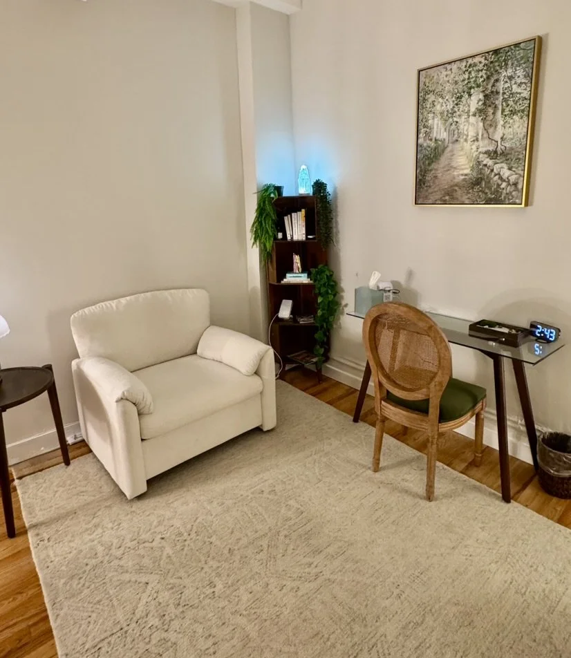 Midtown Manhattan therapy room with a cream armchair and a landscape painting