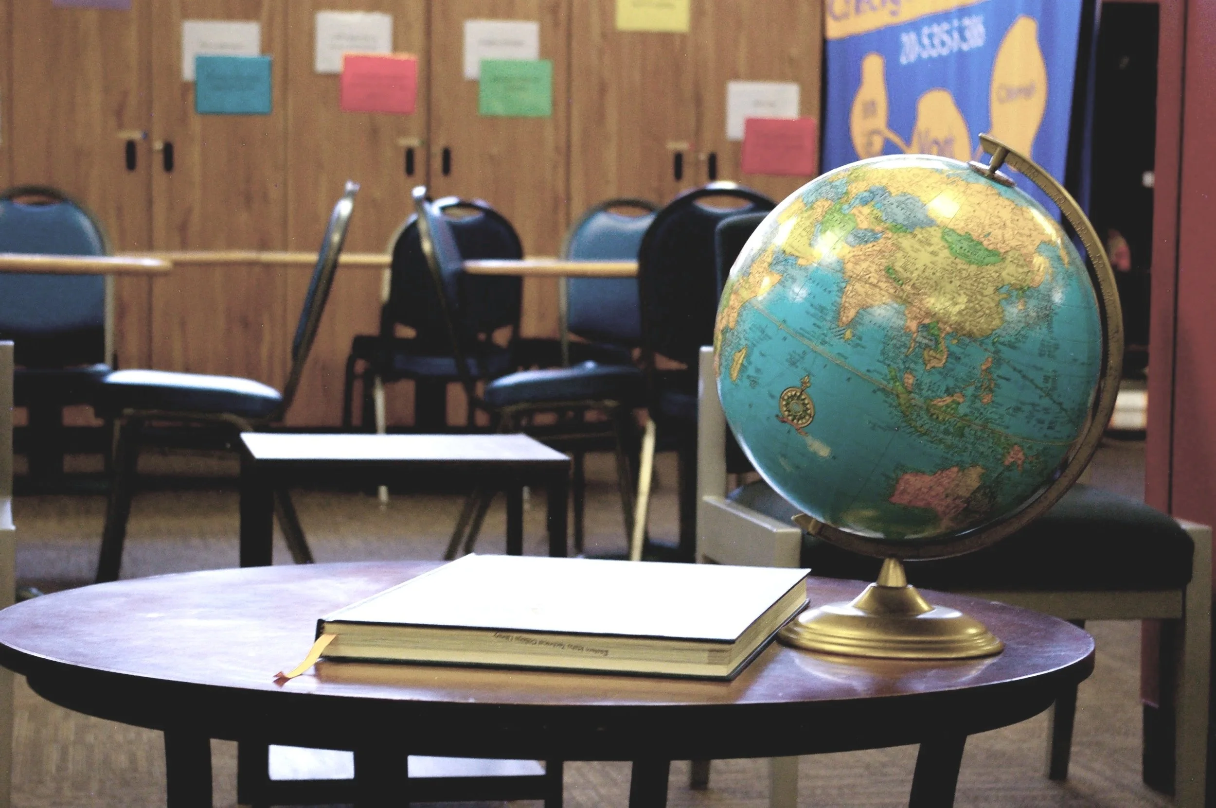Stack of colorful books arranged vertically with a plain blurred background.