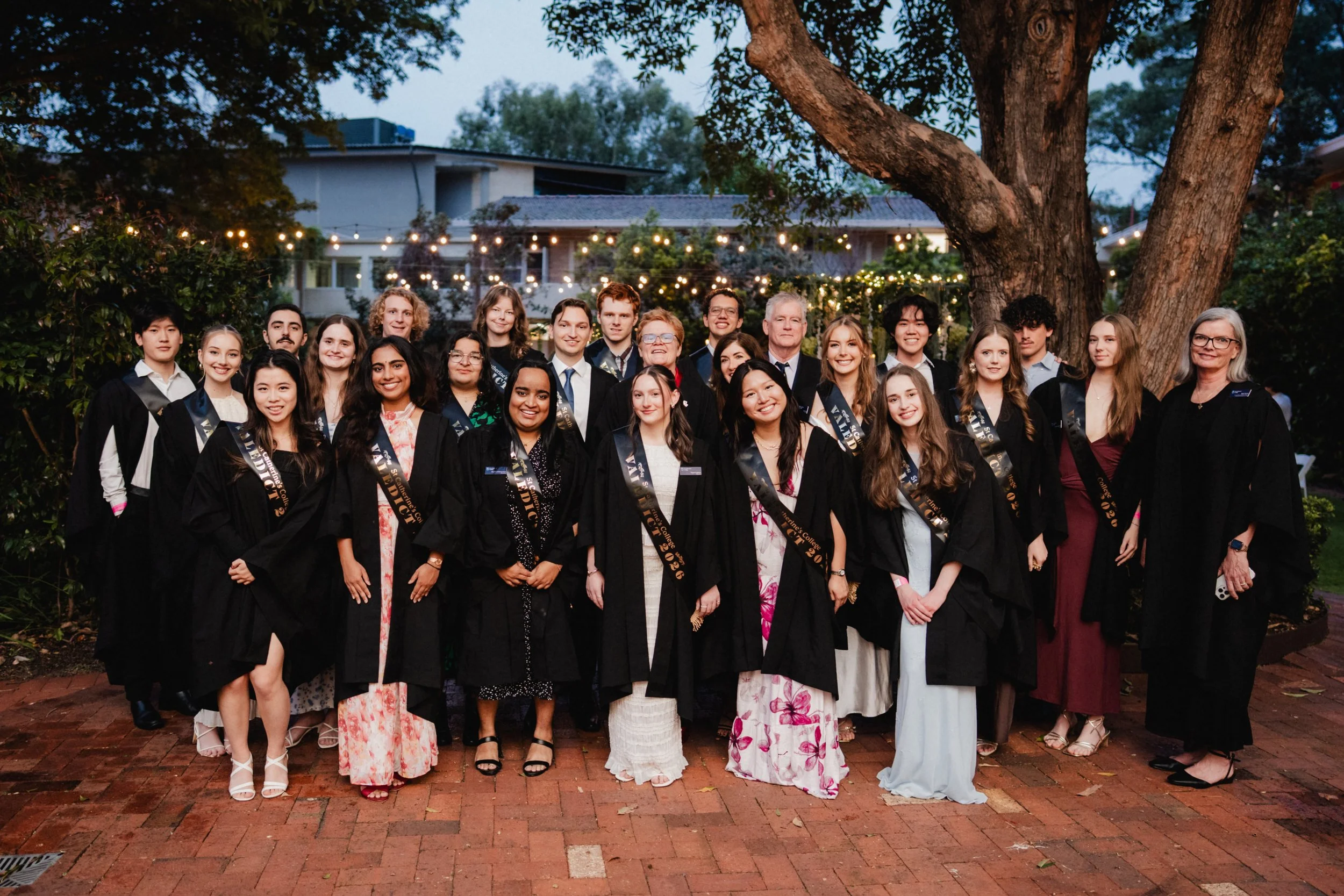 2026 UWA valedicts wearing academic gowns and sashes at St Catherine’s College’s A Midsummer Night’s Dream Valedictory Dinner in Perth.