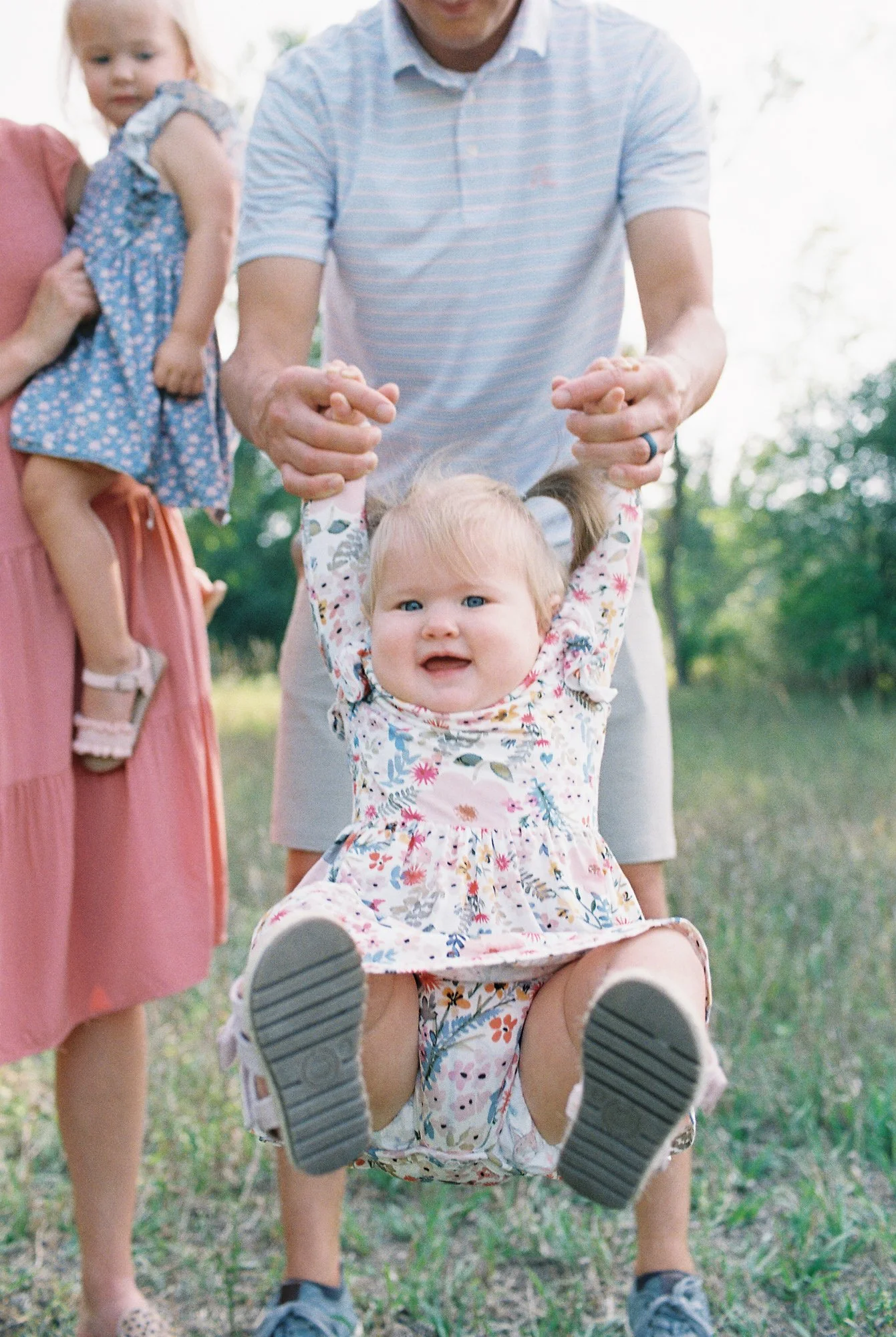 A lifestyle photograph of a family playing together outside.
