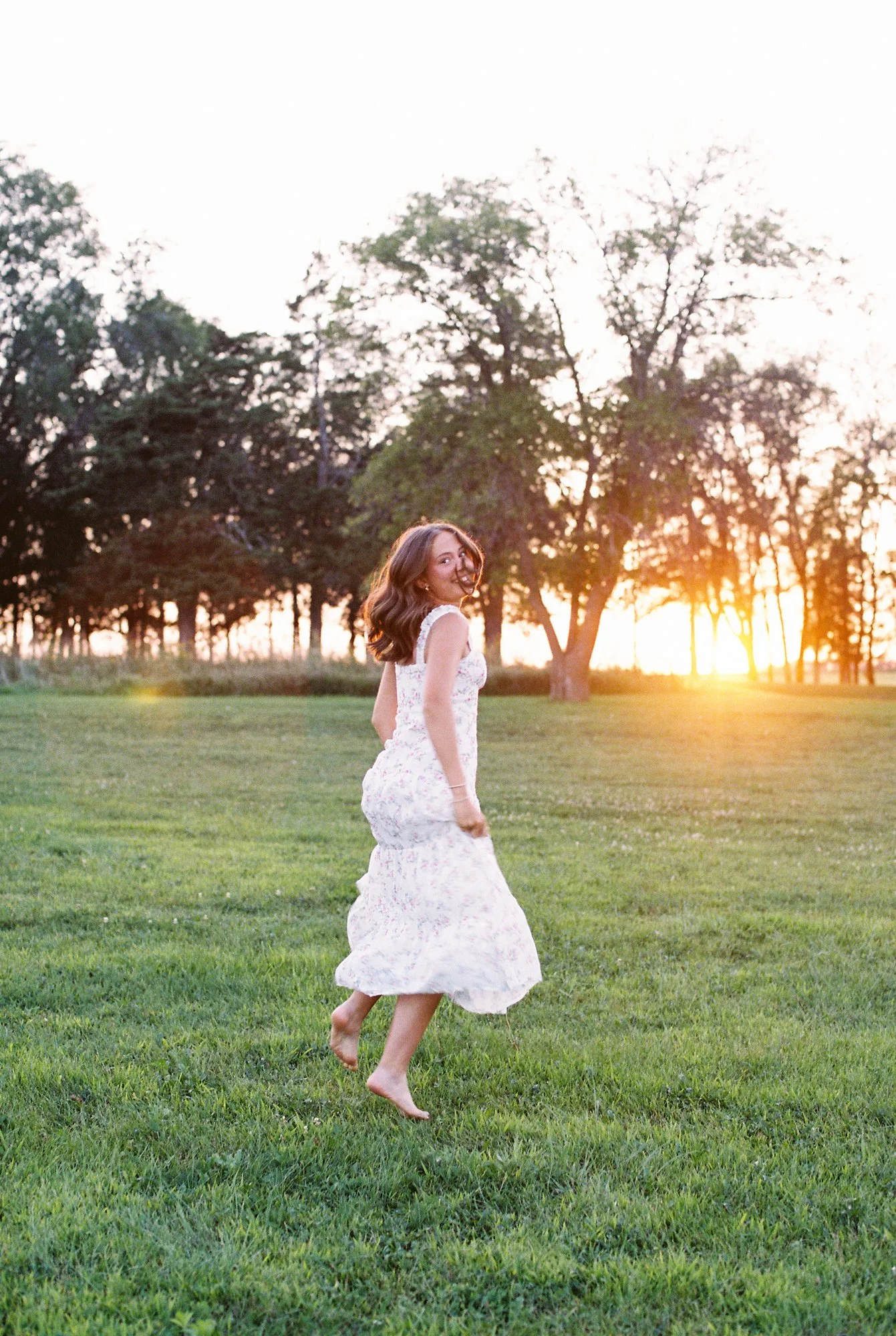 Artistic senior portrait with playful energy and soft film texture