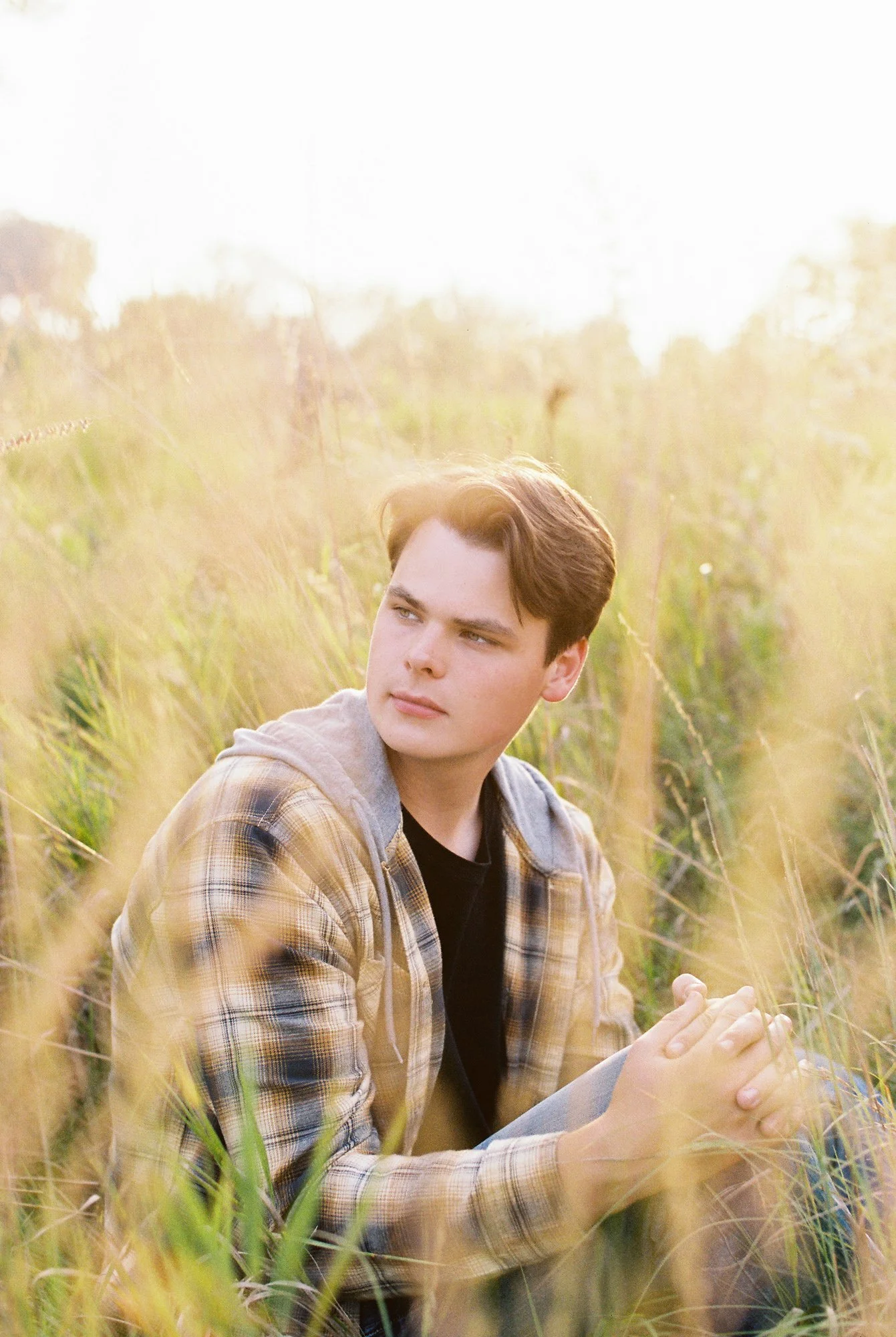 Artistic senior portrait with playful energy and soft film texture