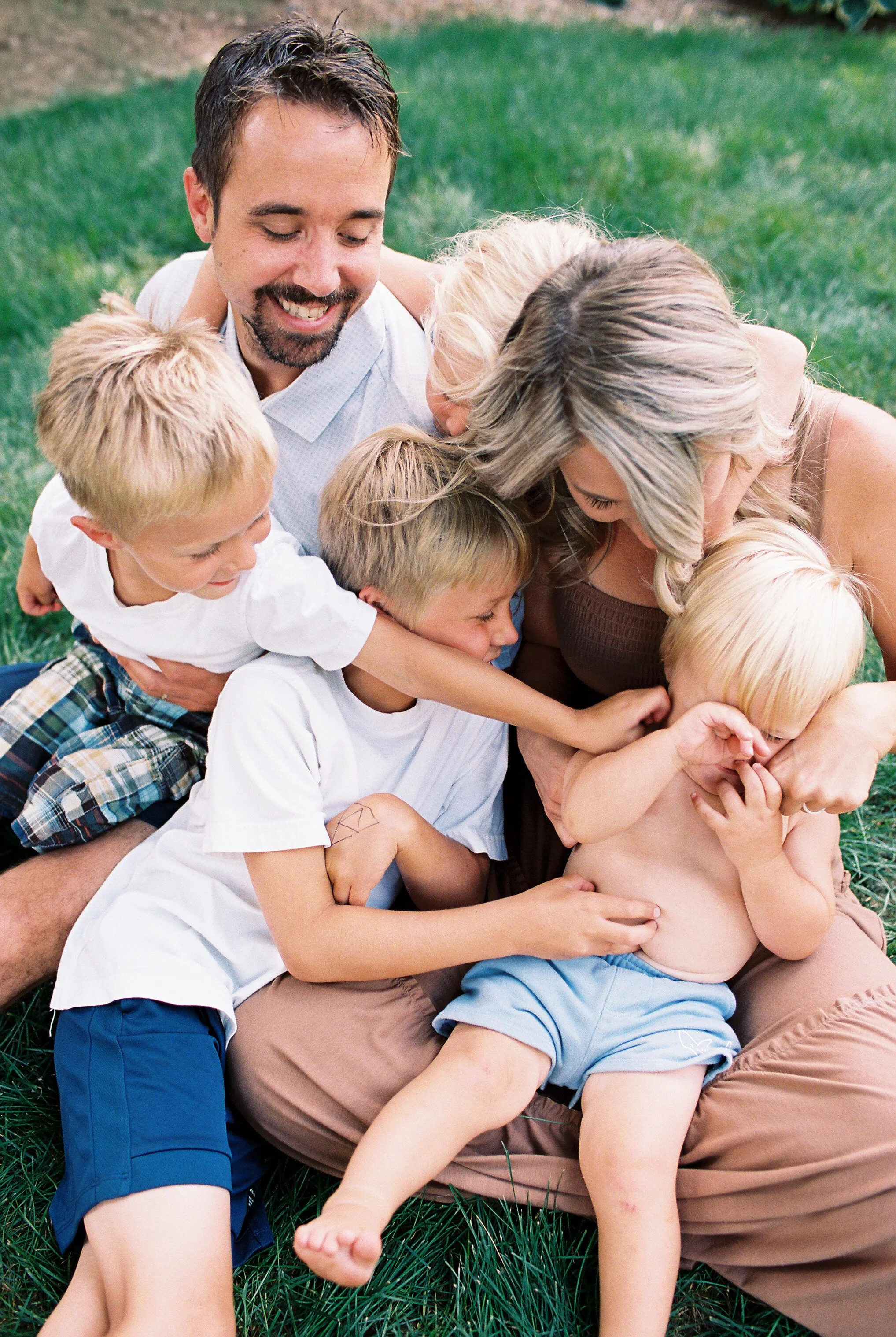 A family snuggled together playing in their backyard.