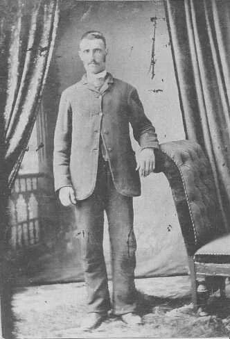 Photo ancienne d'un homme debout dans un studio de photographe