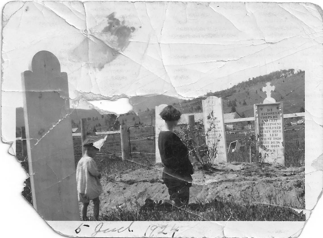 femme agenouilée devant des pierres tombales. Derrière elle un jeune enfant. Paysage rural.