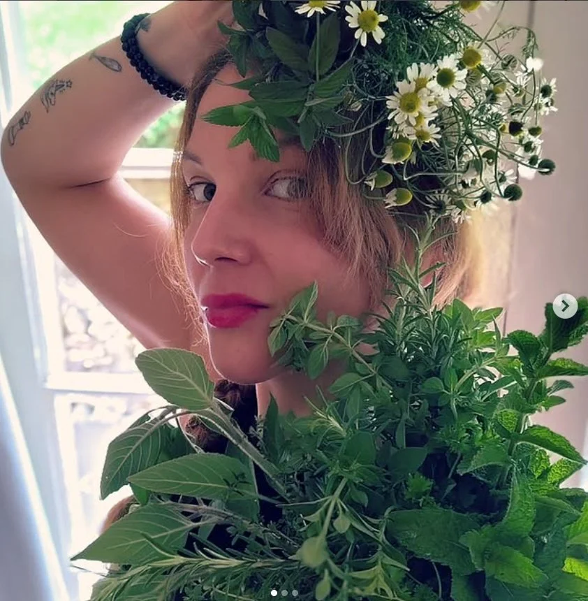 woman holding fresh herbs and flowers