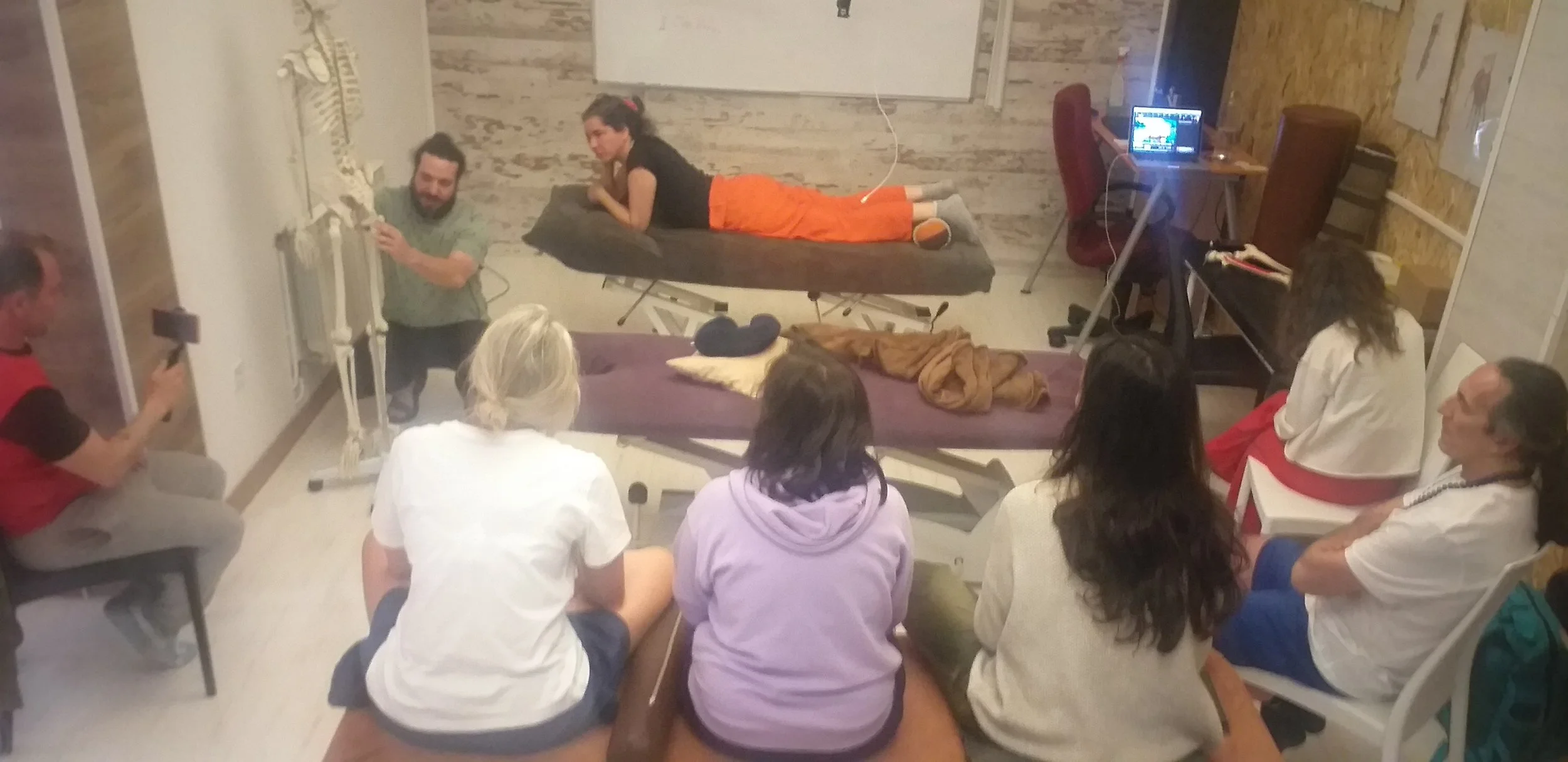 ragmento de una clase del curso de Miofascial en el centro de formación HARA en madrid, donde los alumnos están atendiendo explicaciones para reproducir posteriormente la práctica guiada