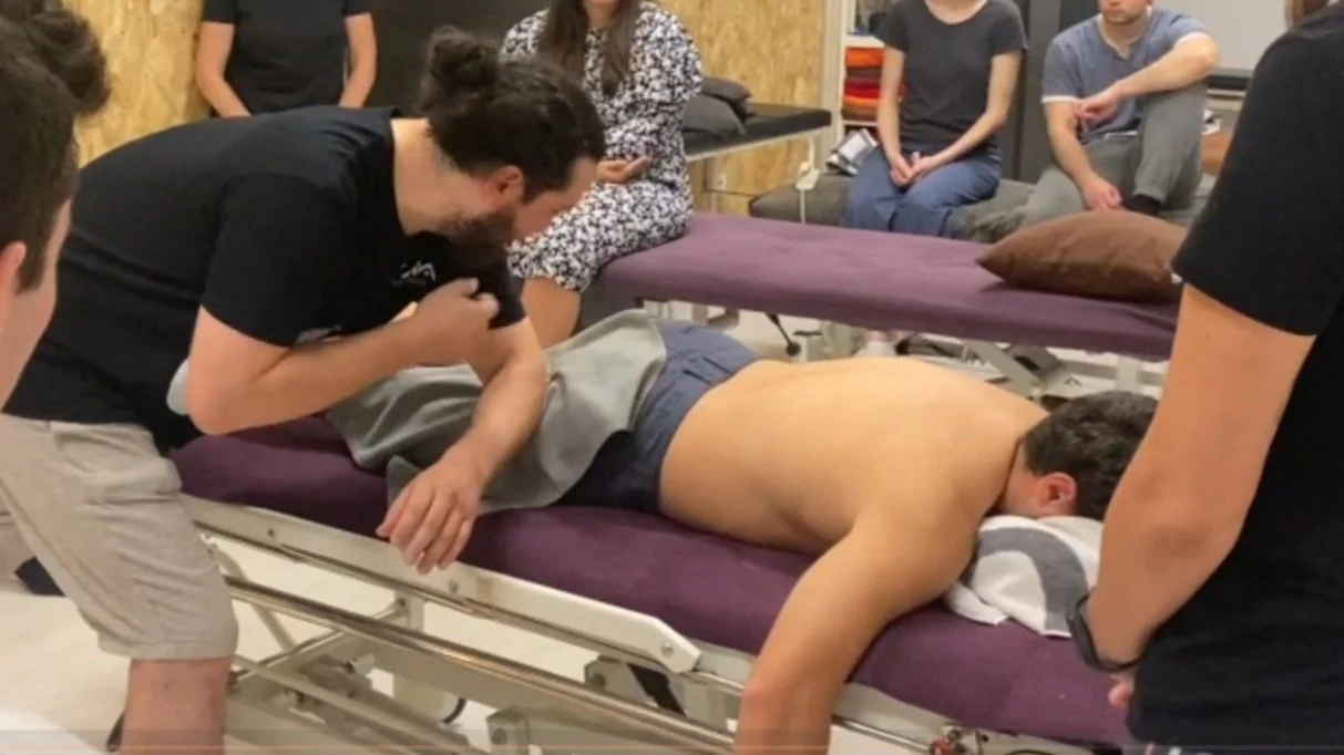 Foto de la explicación teórica para la práctica guiada del abordaje sobre isquiotibiales utilizando técnica directa miofascial, durante el curso de Terapia Miofascial en el centro de formación HARA en Madrid ,