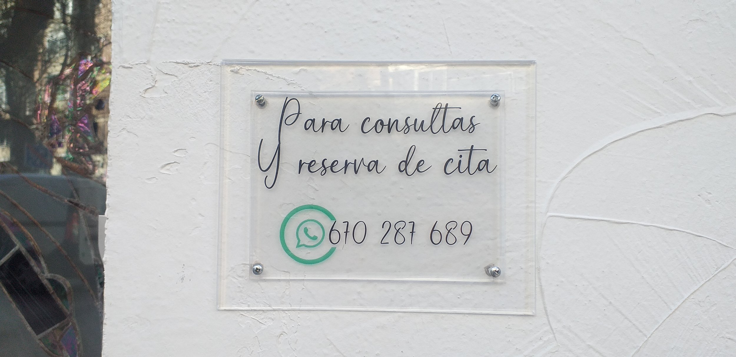 Placa con el número de teléfono para concertar citas para sesiones de Fisioterapia, Osteopatía y Acupuntura en el centro de fisioterapia HARA