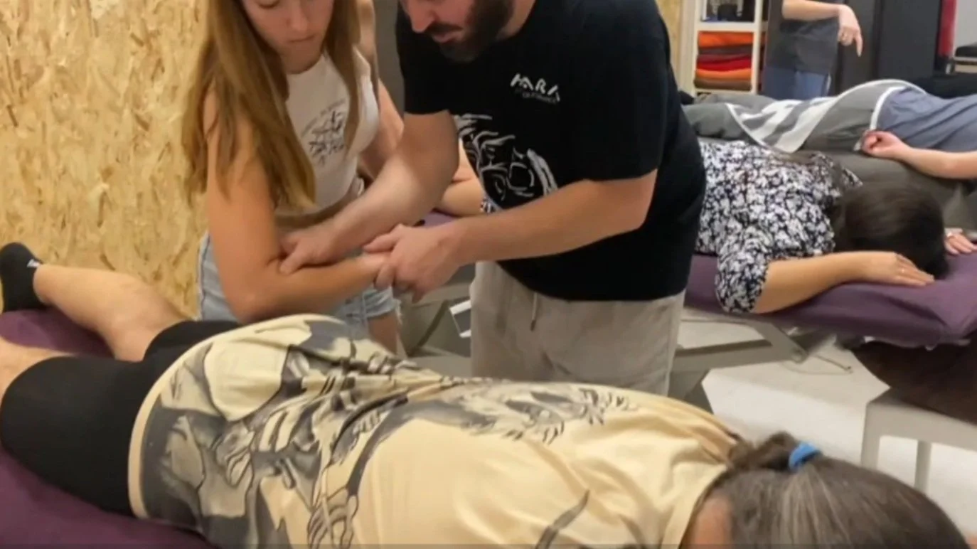 Corrección durante la práctica de un curso de Miofascial a una alumna en el tratamiento de isquiotibiales en el centro de formación HARA en Madrid.