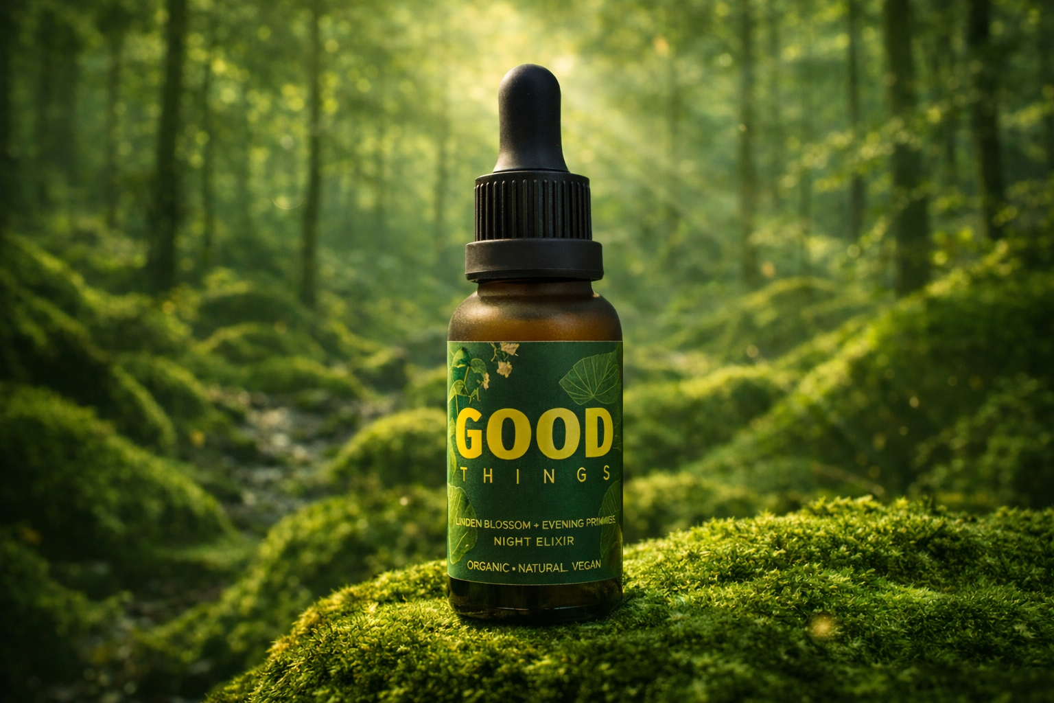 A small brown bottle with a black dropper cap labeled 'Good Things' placed on mossy green ground in a forest with sunlight filtering through trees.