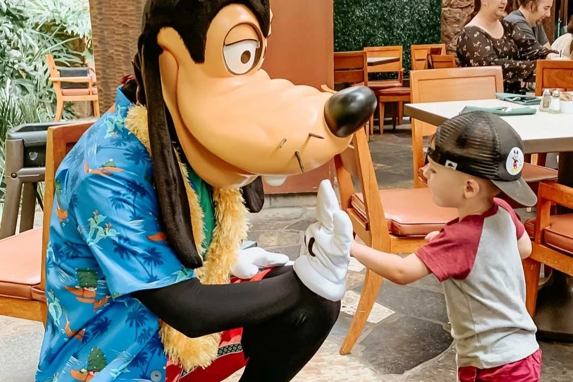 Little boy giving Goofy a high five at the Disney Character Breakfast at Aulani