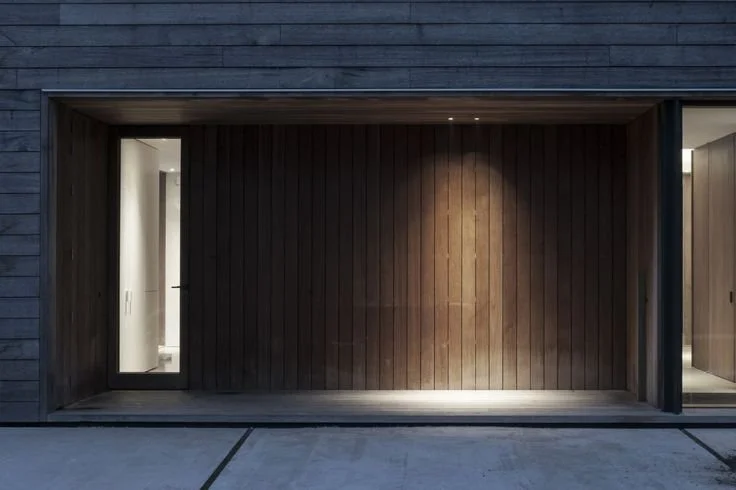 Striking modern building facade illuminated by Rare Studio's architectural lighting design, highlighting structural elements and textures