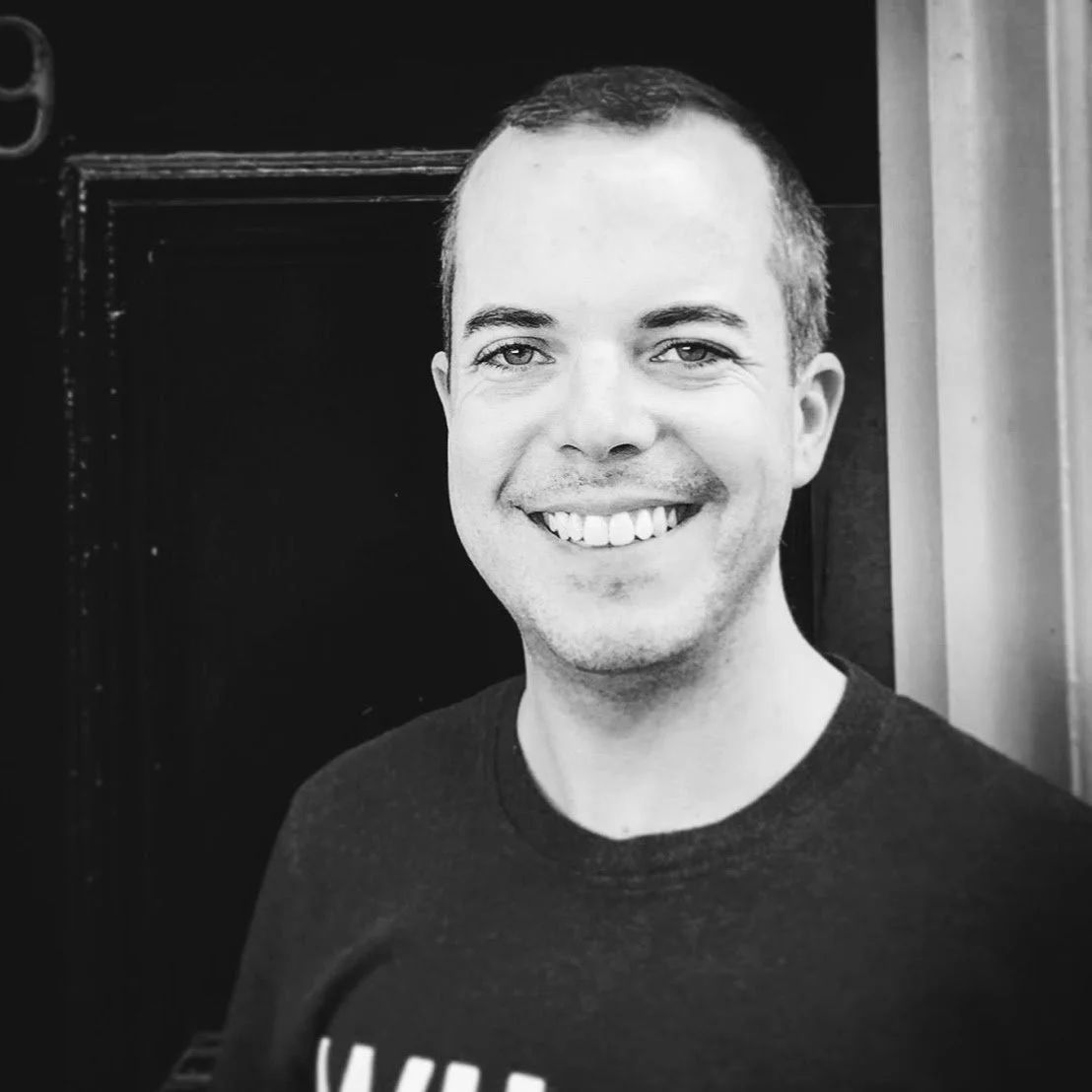 Black and white headshot of Joshua Simpson