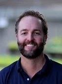 A smiling man with short hair and a beard wearing a gray polo shirt with the 'Native West Nursery' logo