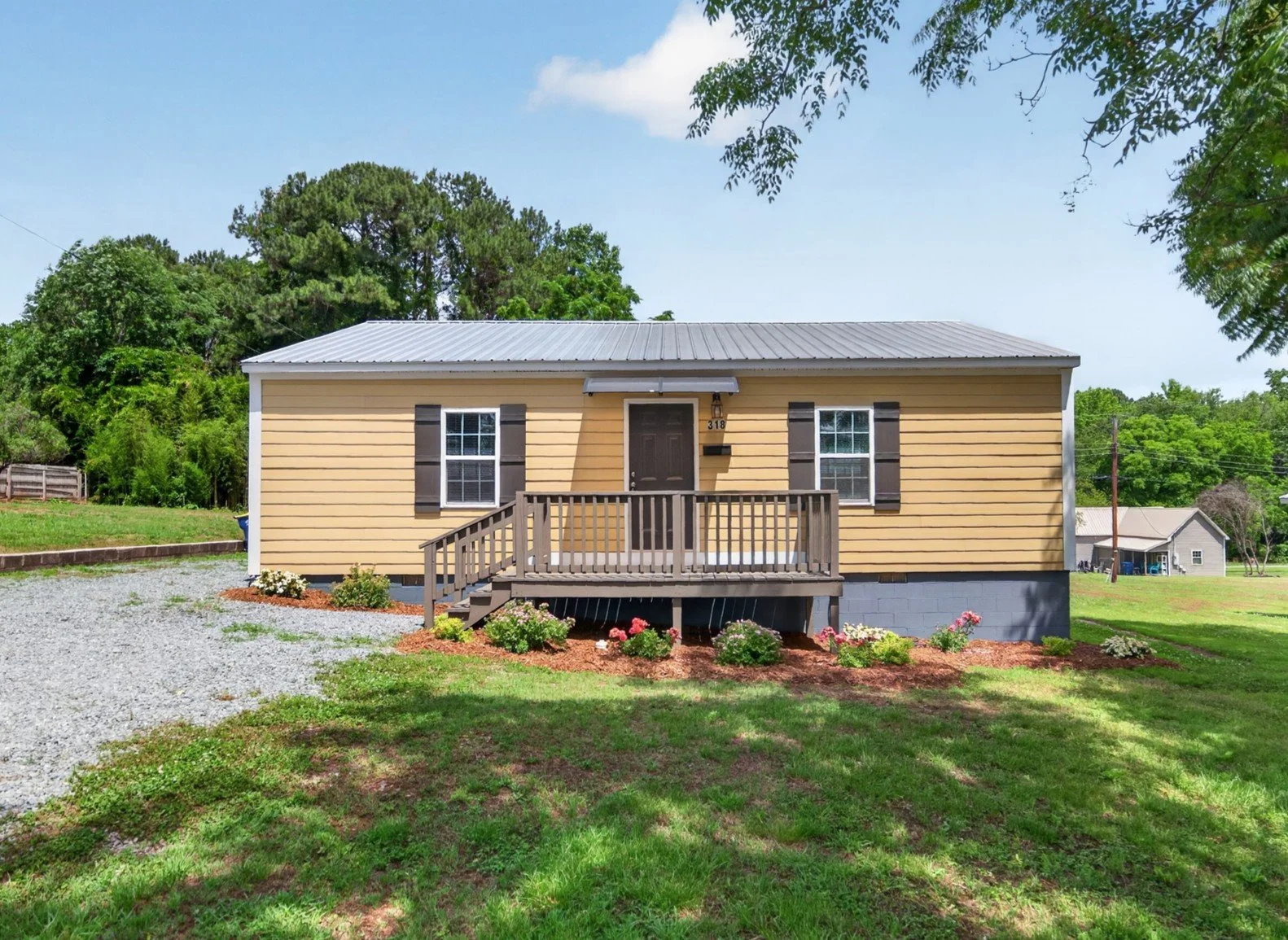 Front of Home with covered entry, freshly painted porch, and XL gravel driveway