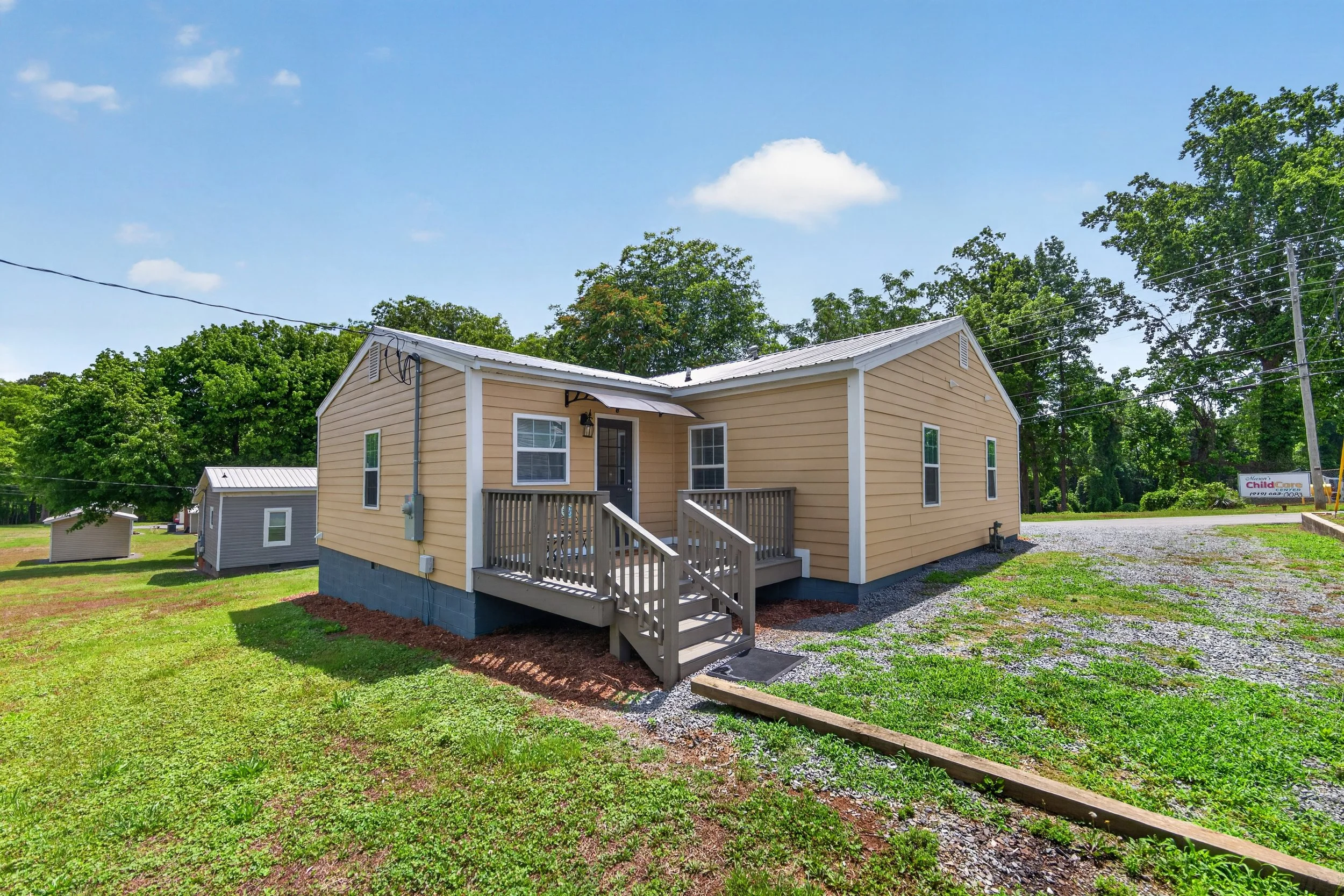 Back of Home with covered entry to separate utility room and freshly painted deck