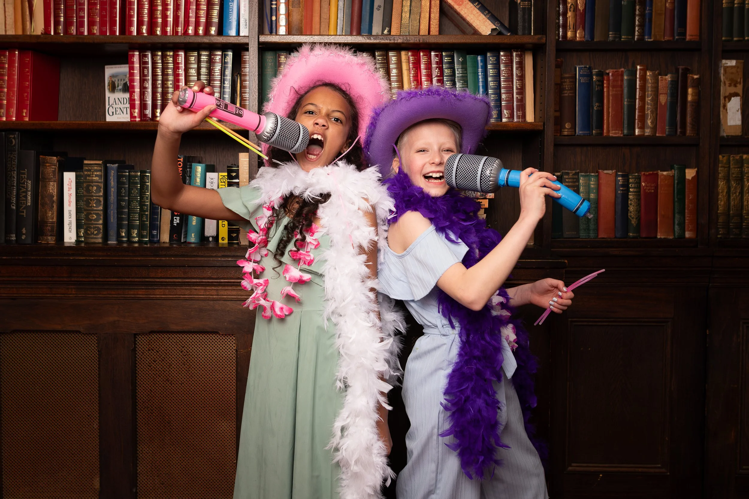 Girls just want to have fun. Photo Booth image of two girls singing into a microphones.