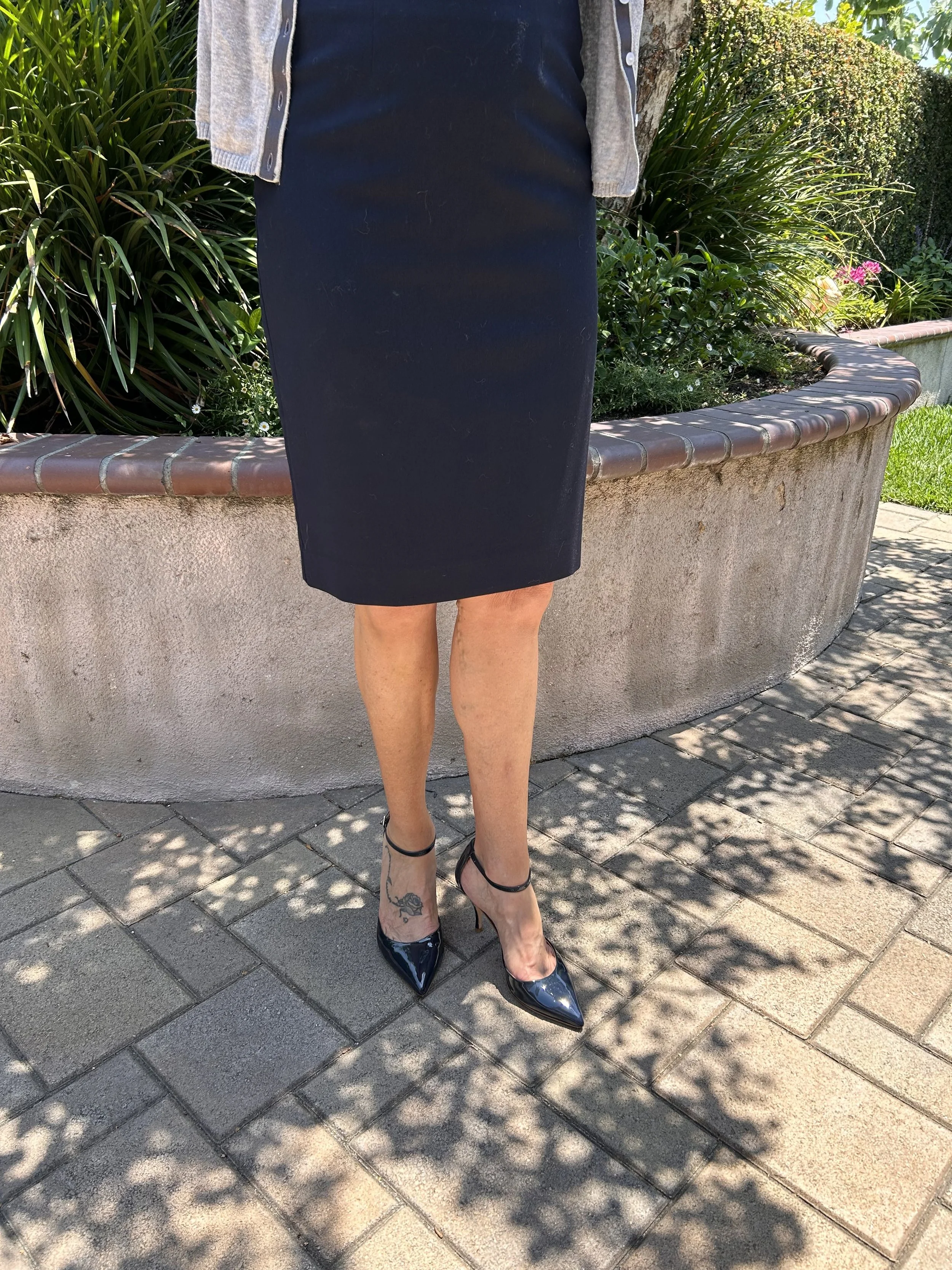 A woman wearing a knee length skirt to an outdoor summer funeral.