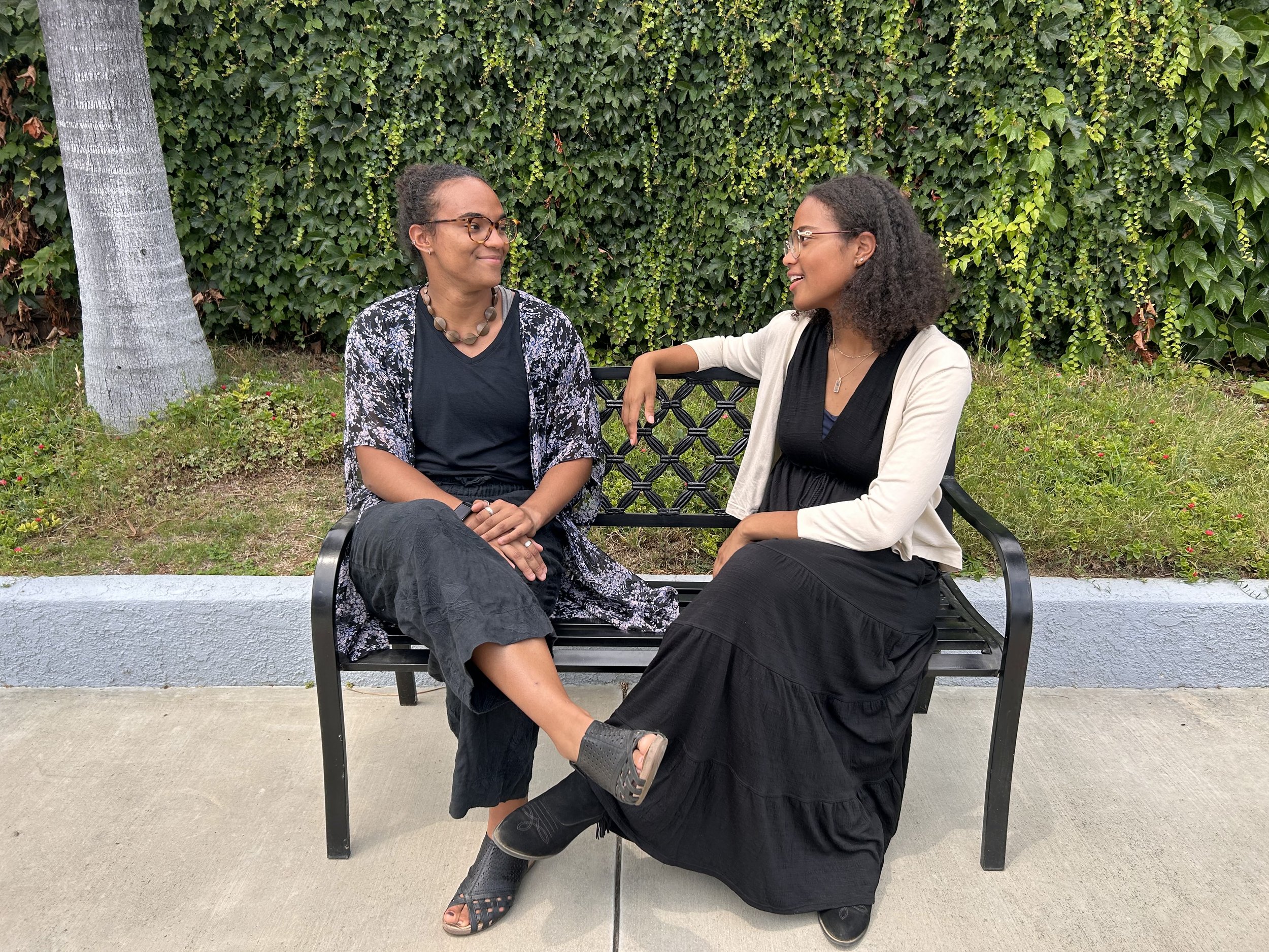 2 women at a summer funeral wearing dark clothes
