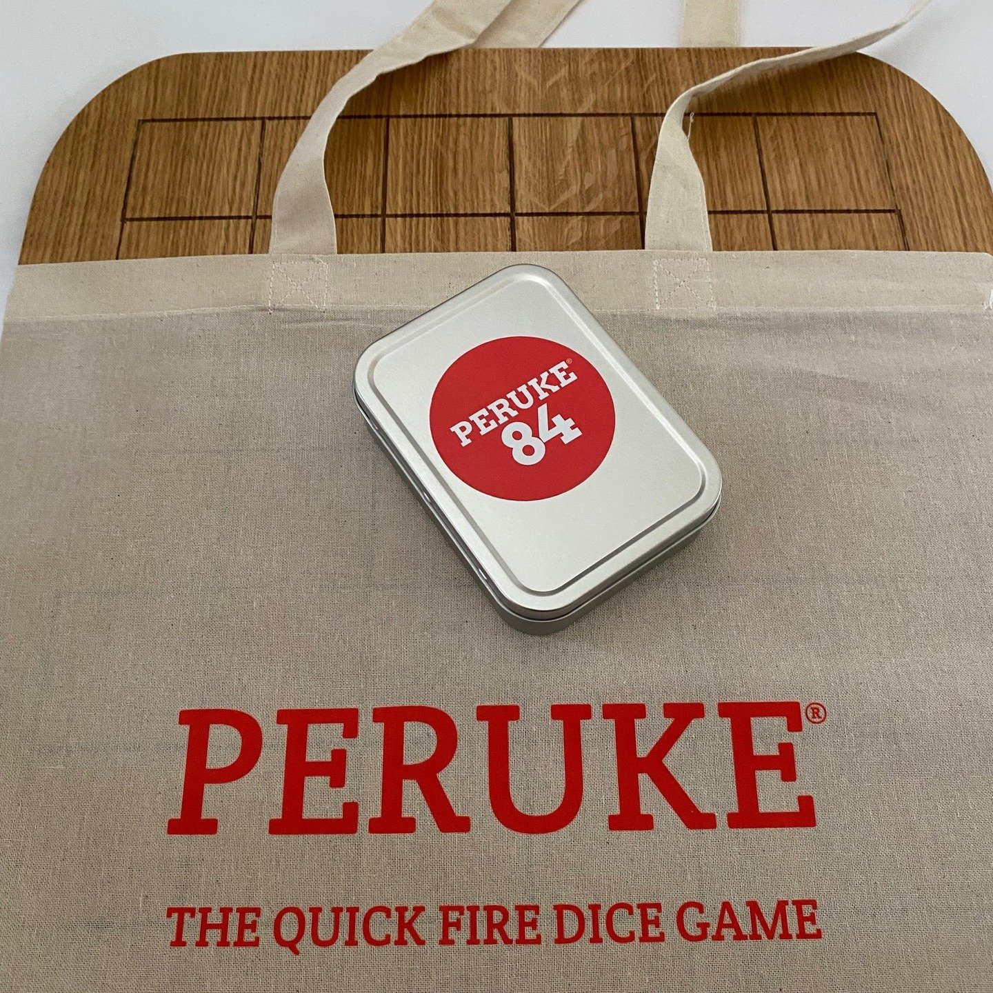 Peruke 84 is now available on the website 🎲 🎲 🎲 It comes with either red &amp; plain discs, blue &amp; plain discs or red &amp; blue discs, along with a beautiful unique 4mm oak veneered board. First sets sold come with a Peruke tote bag that fits