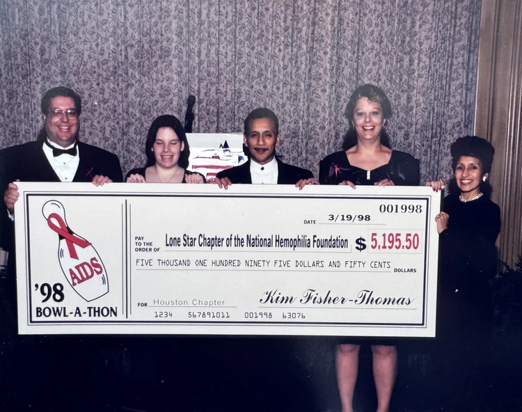 Five people in evening dress holding an oversized cheque from the 1998 Bowl-A-Thon, made out to the Lone Star Chapter of the National Hemophilia Foundation