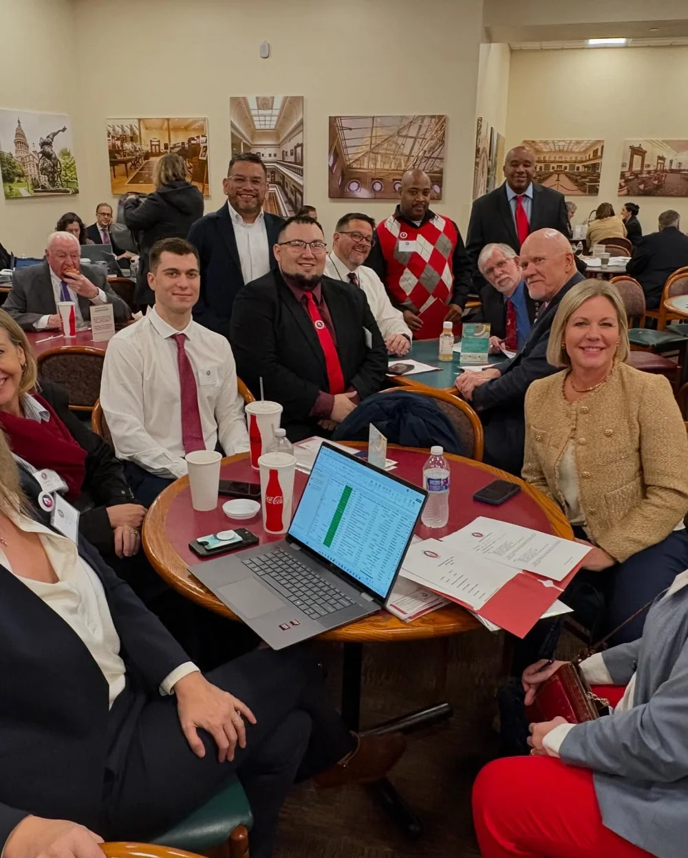 Advocates seated around a table at the Texas Capitol during Austin Days, briefing materials and a laptop in front of them